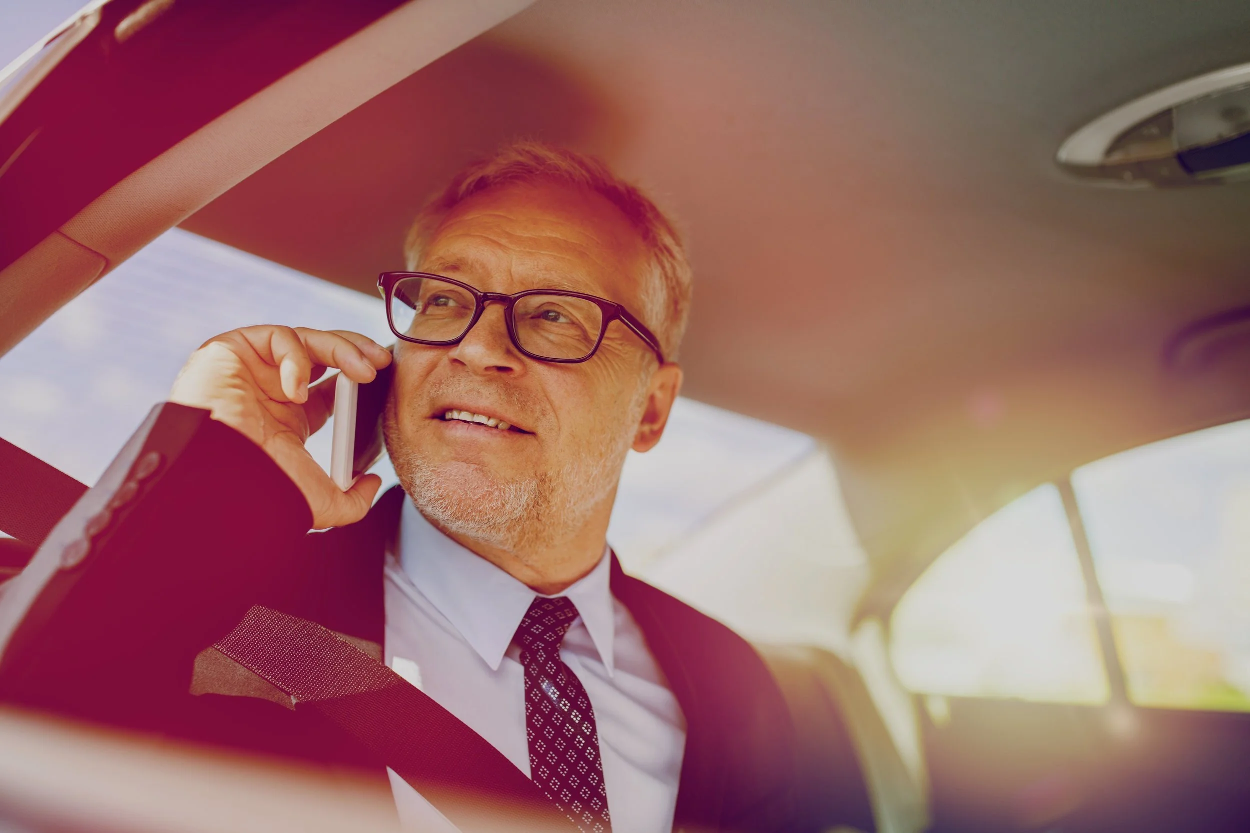senior-businessman-calling-on-smartphone-in-car-PZTGPE8.jpg