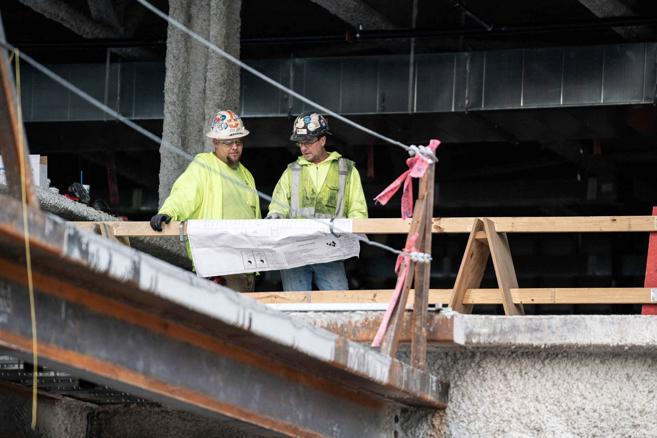 Construction workers examine plans.