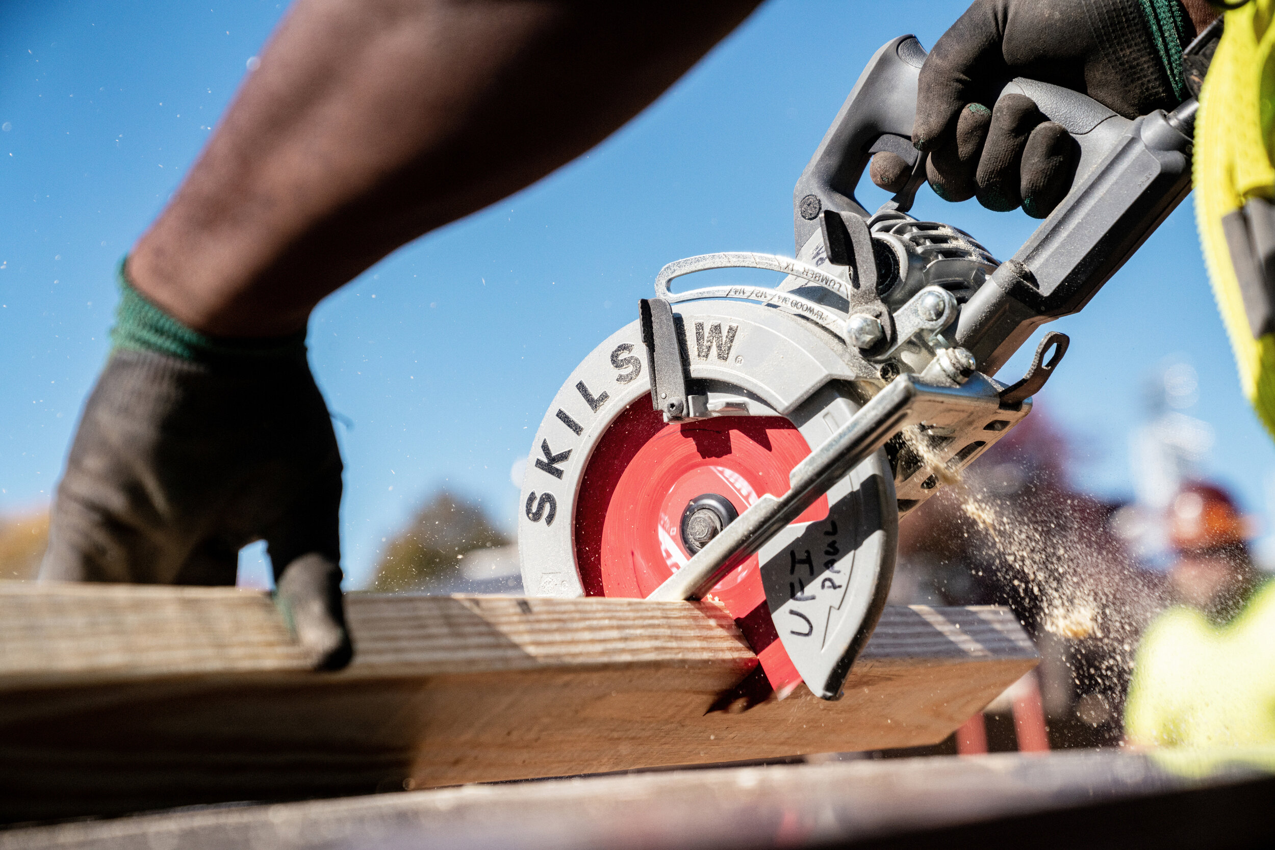 Construction worker cutting wood with a circular saw.
