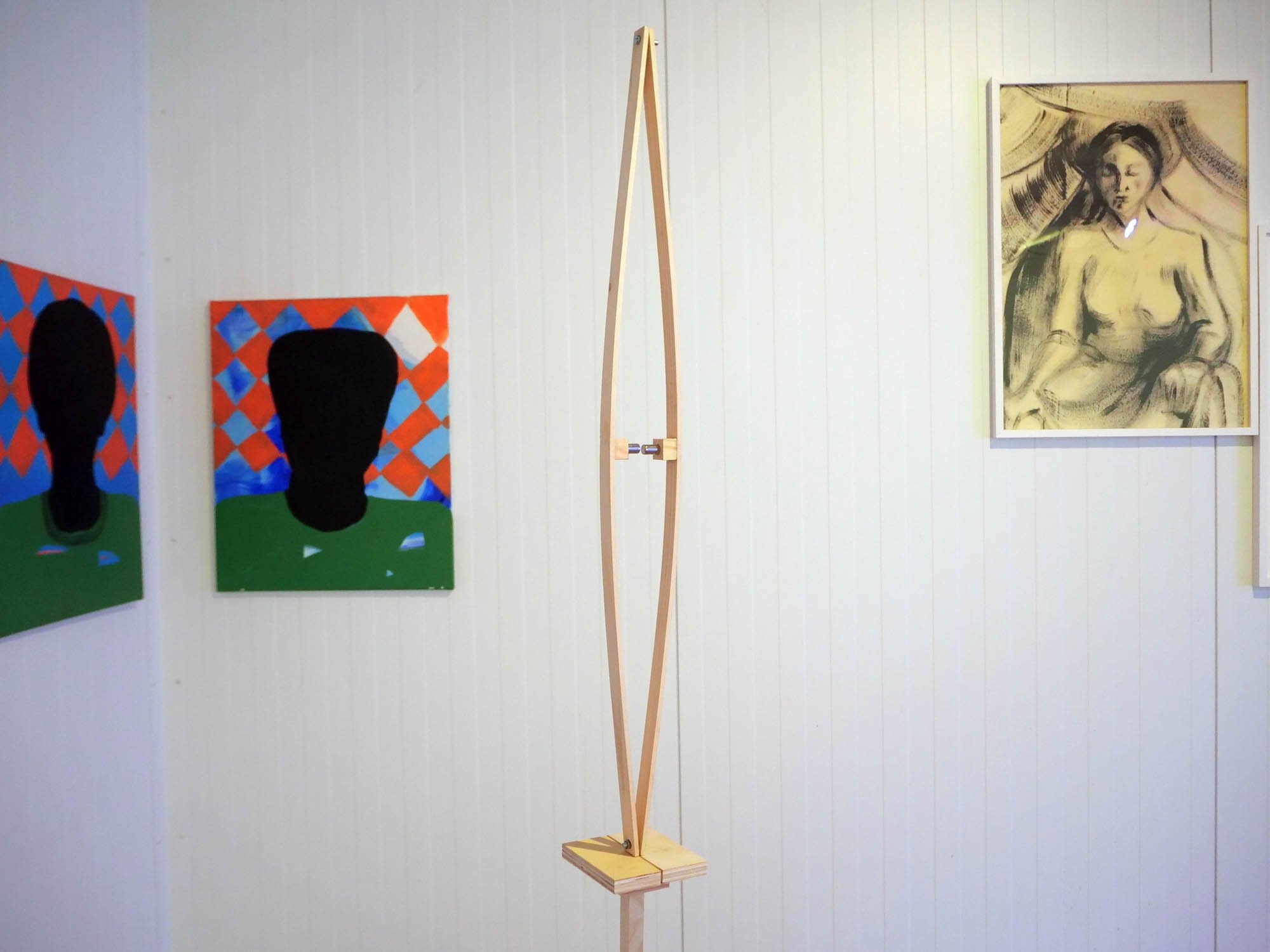  Shot from the exhibition. The wood and magnet sculpture in front is “En tvunget samtale” (2021) by Robert Julian Badenhope Hvistendahl.  On the wall behind (from the left) we see “Men” (2020), acrylic on canvas, by Fadlabi and “untitled” (1980), acr