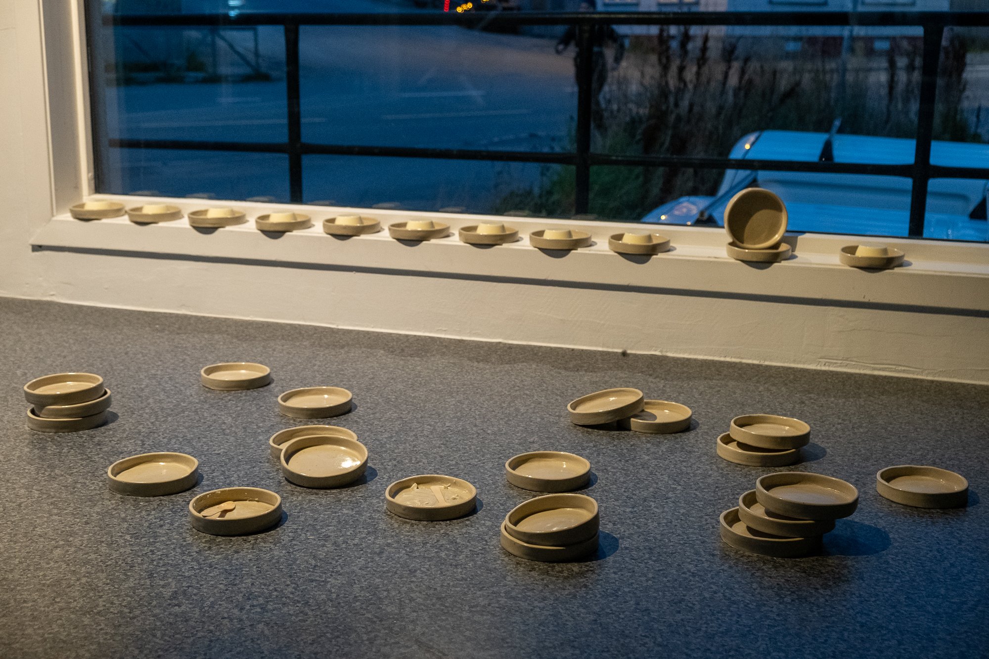   May contain breast milk  (2025), ceramic plates by soso brafield. During the vernisage of the exhibition  Milk  at Kurant, the plates were used to serve panna cotta made with formular milk. Photo: Kurant 