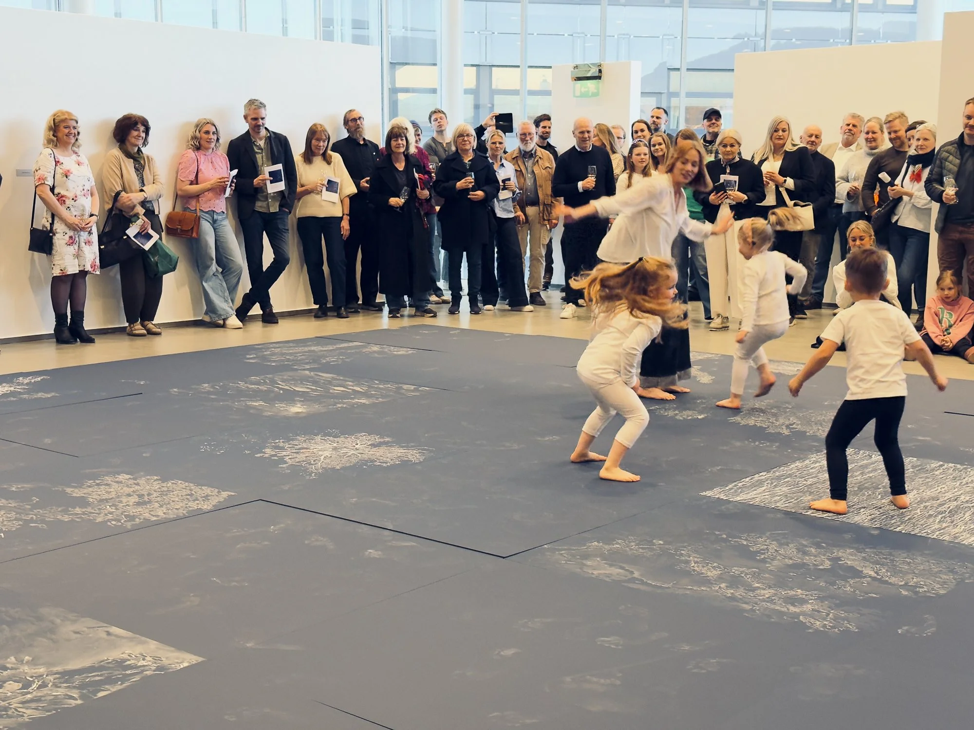  Fra åpningen av utstillingen  Lengsel etter den andre på Galleri Nord-Norge.  På gulvet er verket Å gå på dypet sammen ( 2026) av Ingeborg Annie Lindahl og Marte Huke. Foto: Steve Nilsen 