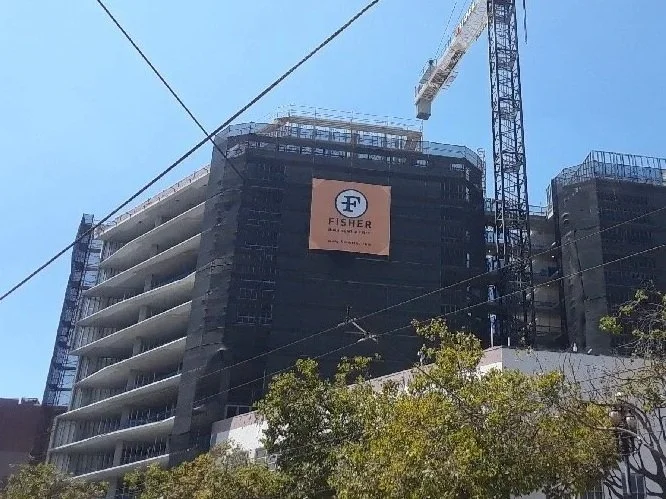 A large/grand format banner applied to a building during construction to use the scaffolding as an advertising opportunity.