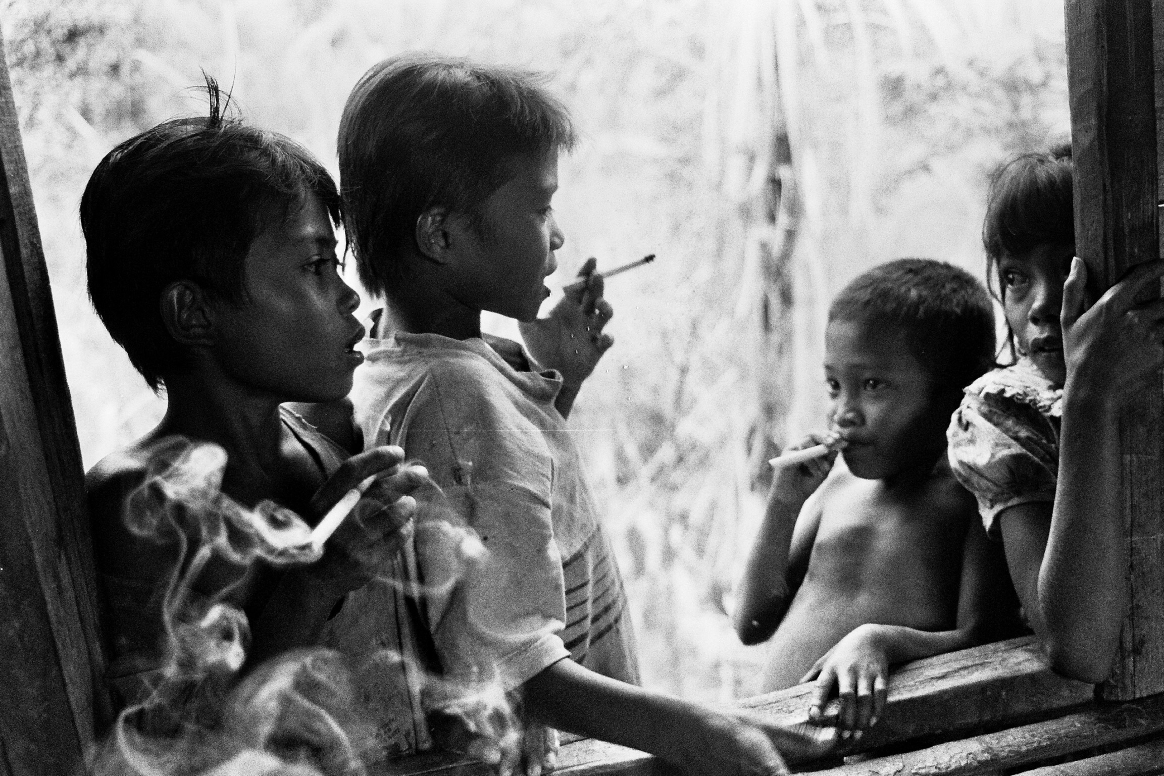 Cigarettes both clove and western had already been brought to the village and were valued by children and adults alike. The girl on the right wasn’t part of the boy gang.