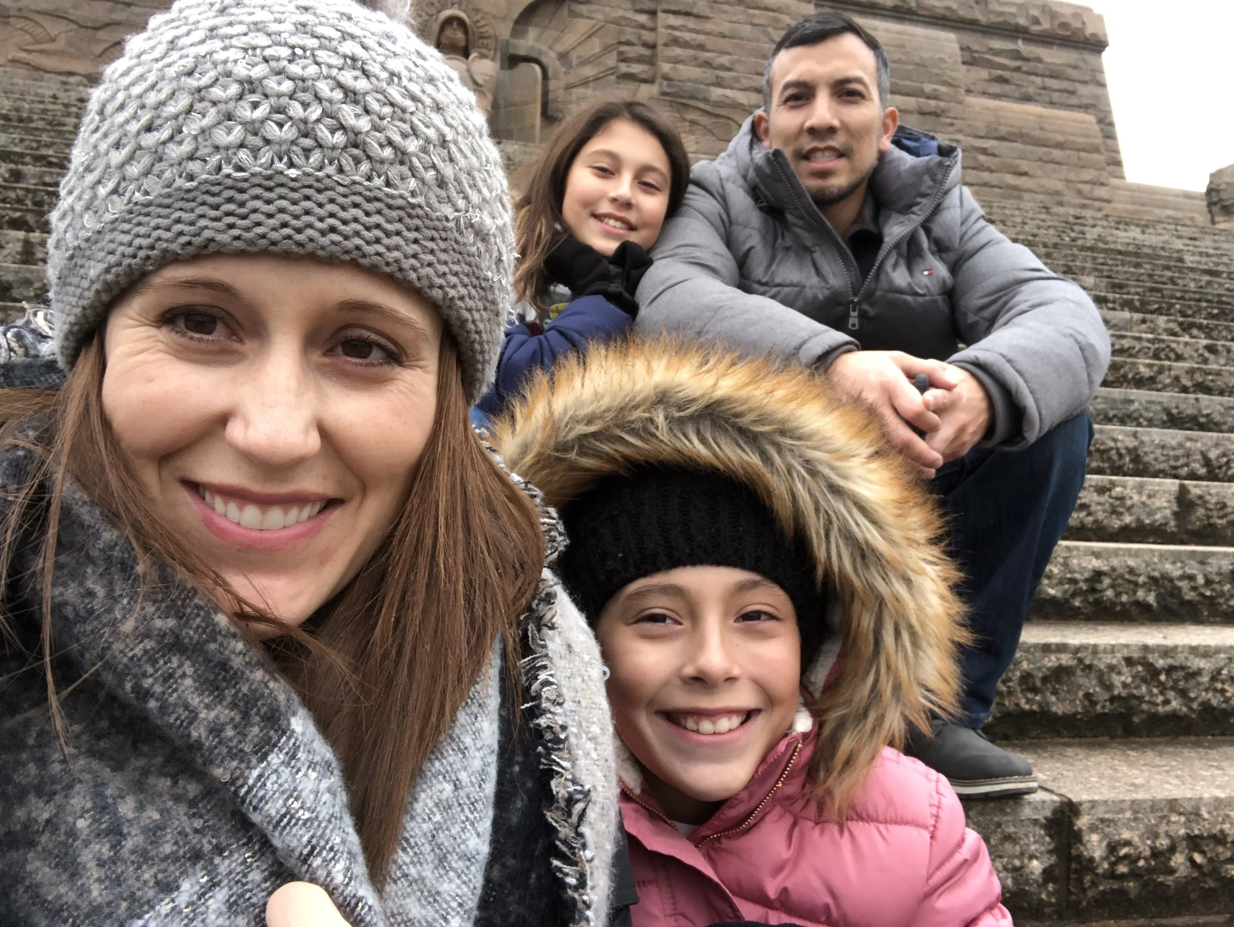 Brandi with her family: Husband Ben Cuevas, and two daughters Kaia (11) and Taelin (10 on July 4th) on the steps of the Battle of Nations monument in Leipzig, Germany.