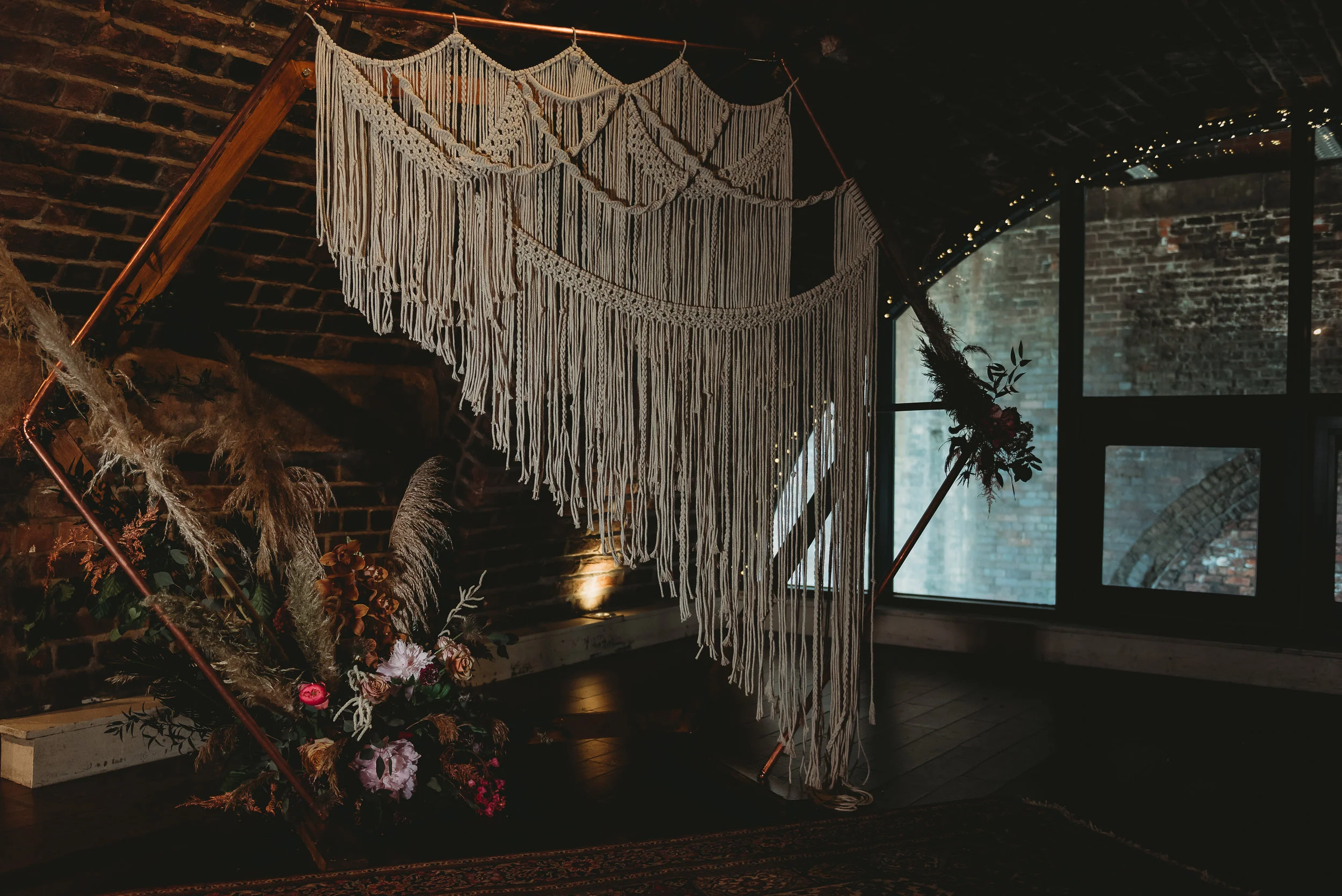 Handmade macrame wedding decor in an industrial wedding venue. See the full shoot here.