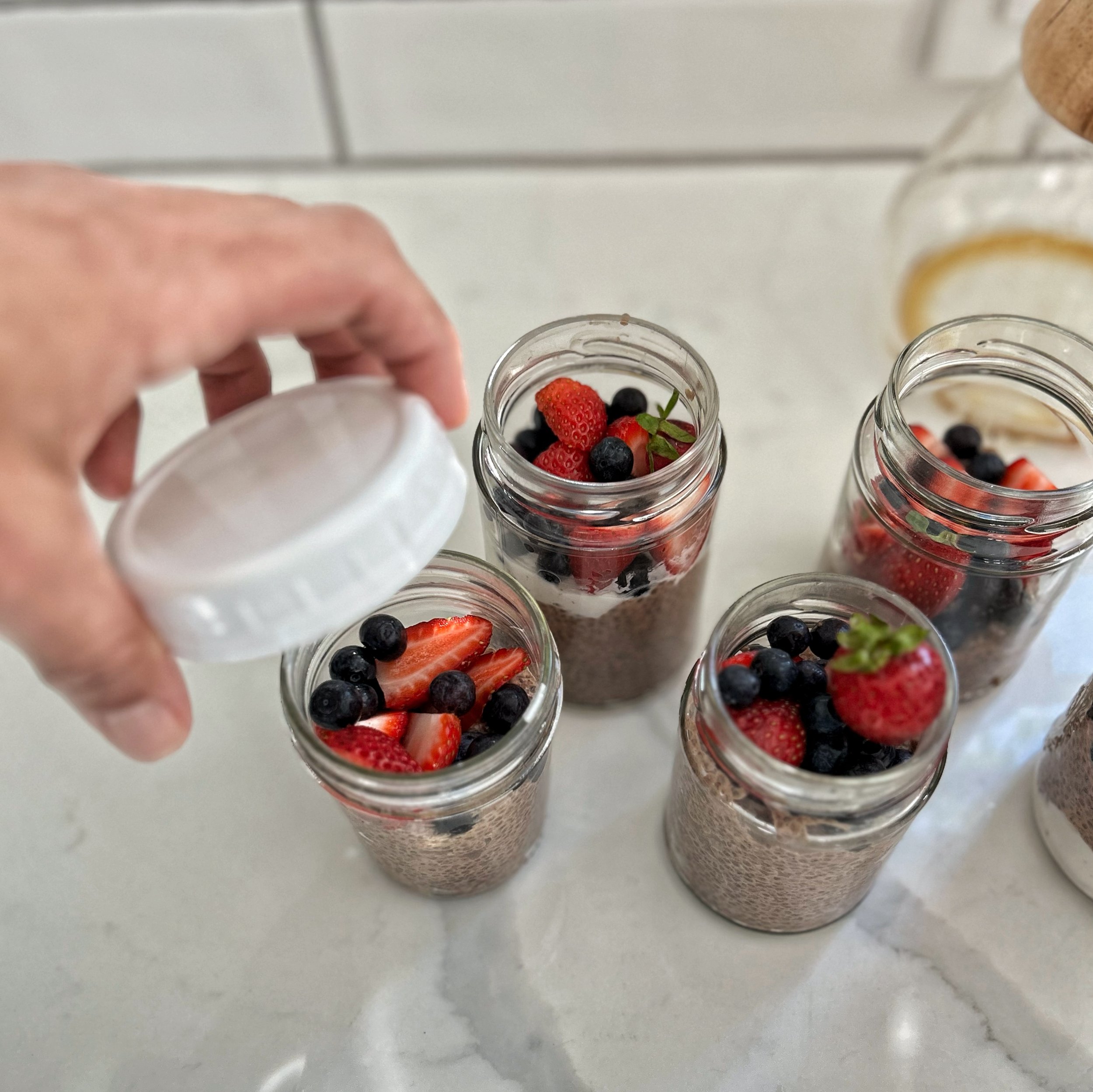 capping jars of chia seed pudding.jpeg