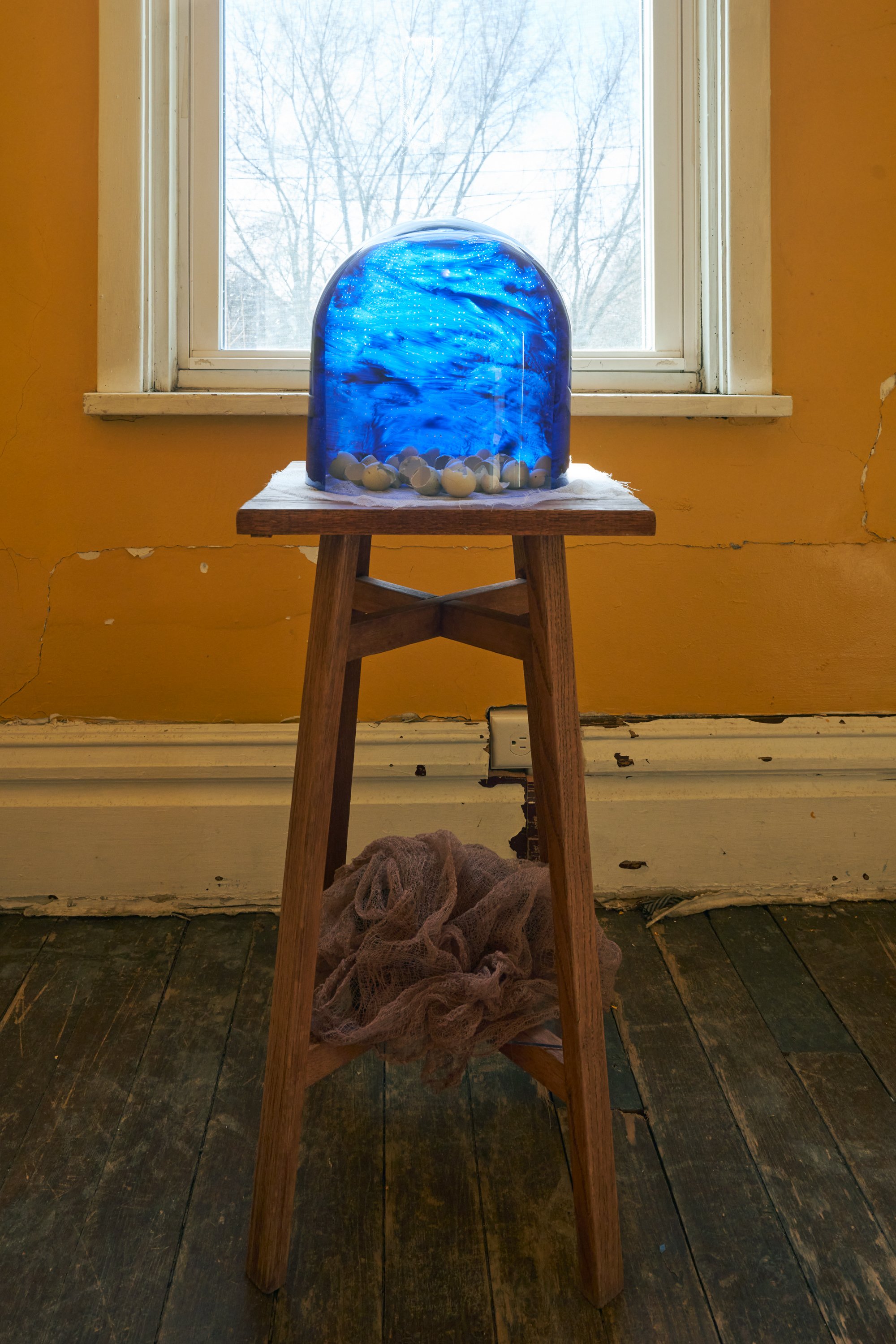   The clerk's wife claims her name, and her own night sky.  2021-2023. Acrylic paint on glass dome, celadon quail eggs, cheesecloth.  34 x 12 x 13 inches. 
