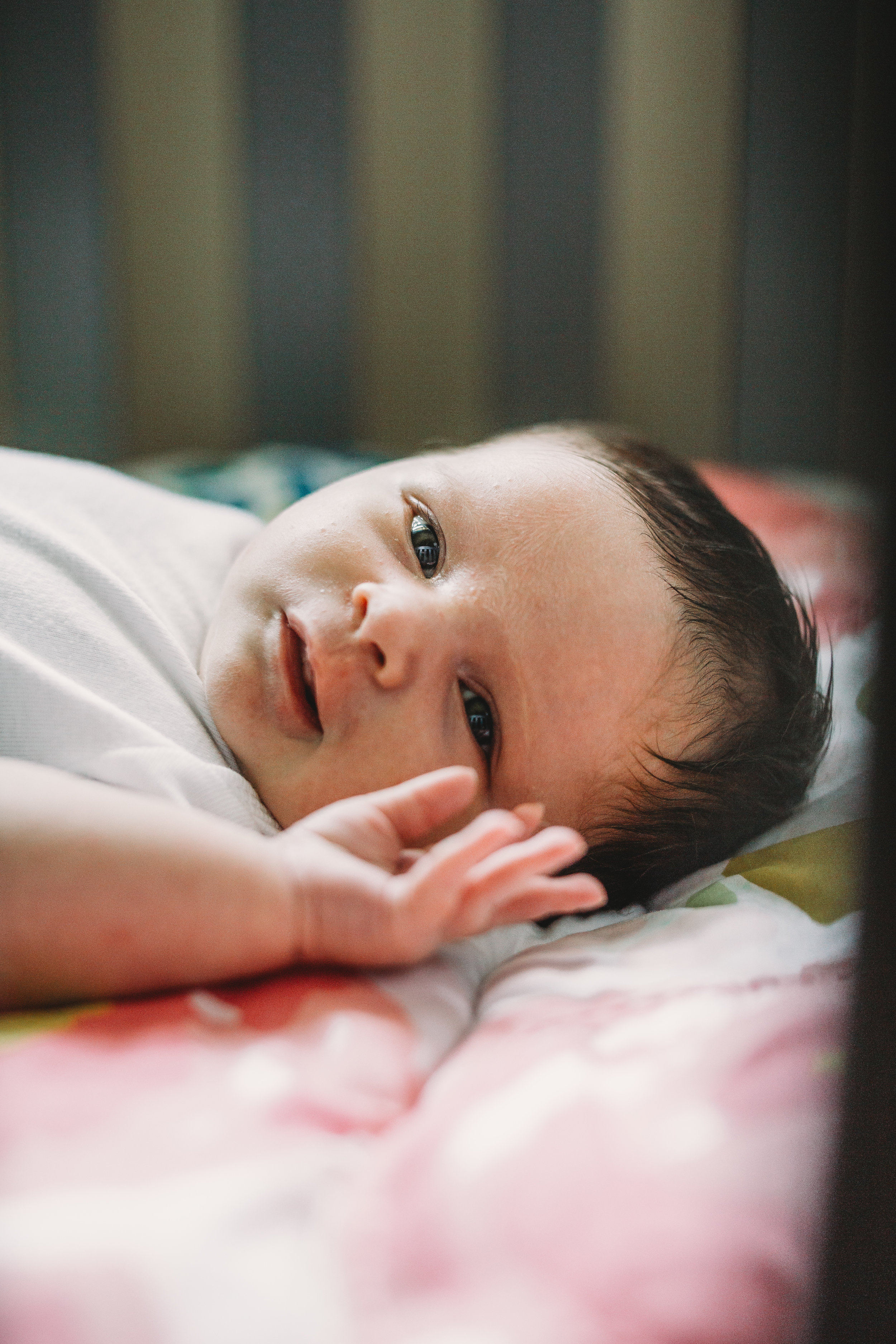 Newborn baby looking at camera in crib