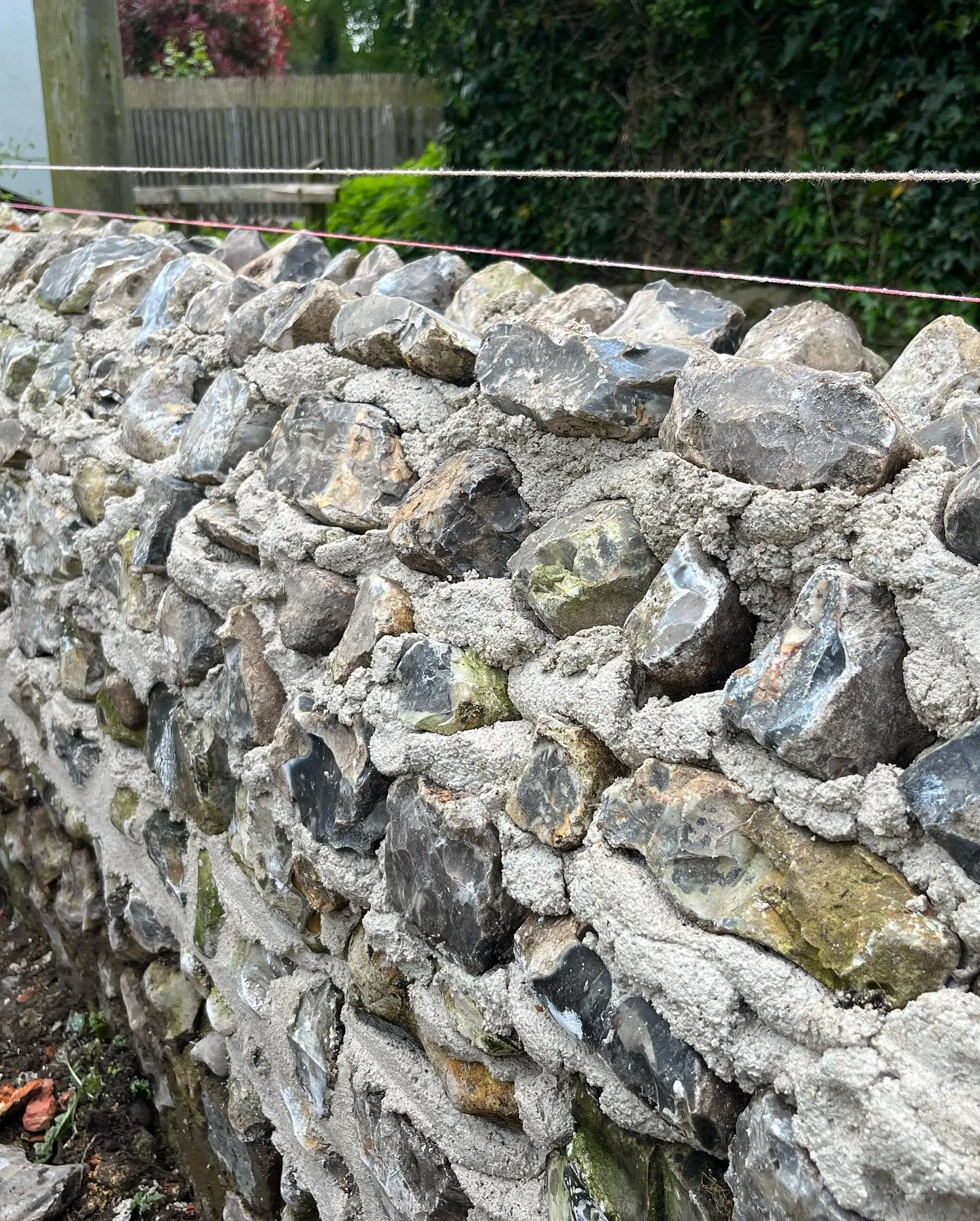 A small flint wall we restored earlier in the year using reclaimed knapped flint #limemortar #hotlime #dorset #brickandflint #flint #heritagebuilding #buildingconservation