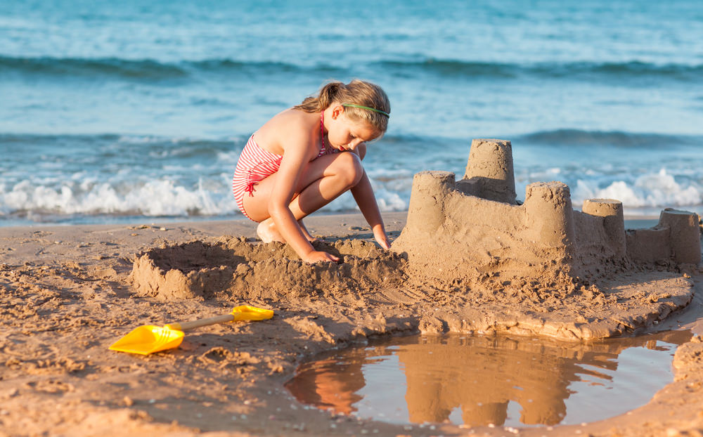 child on beach with sandcastle.jpg