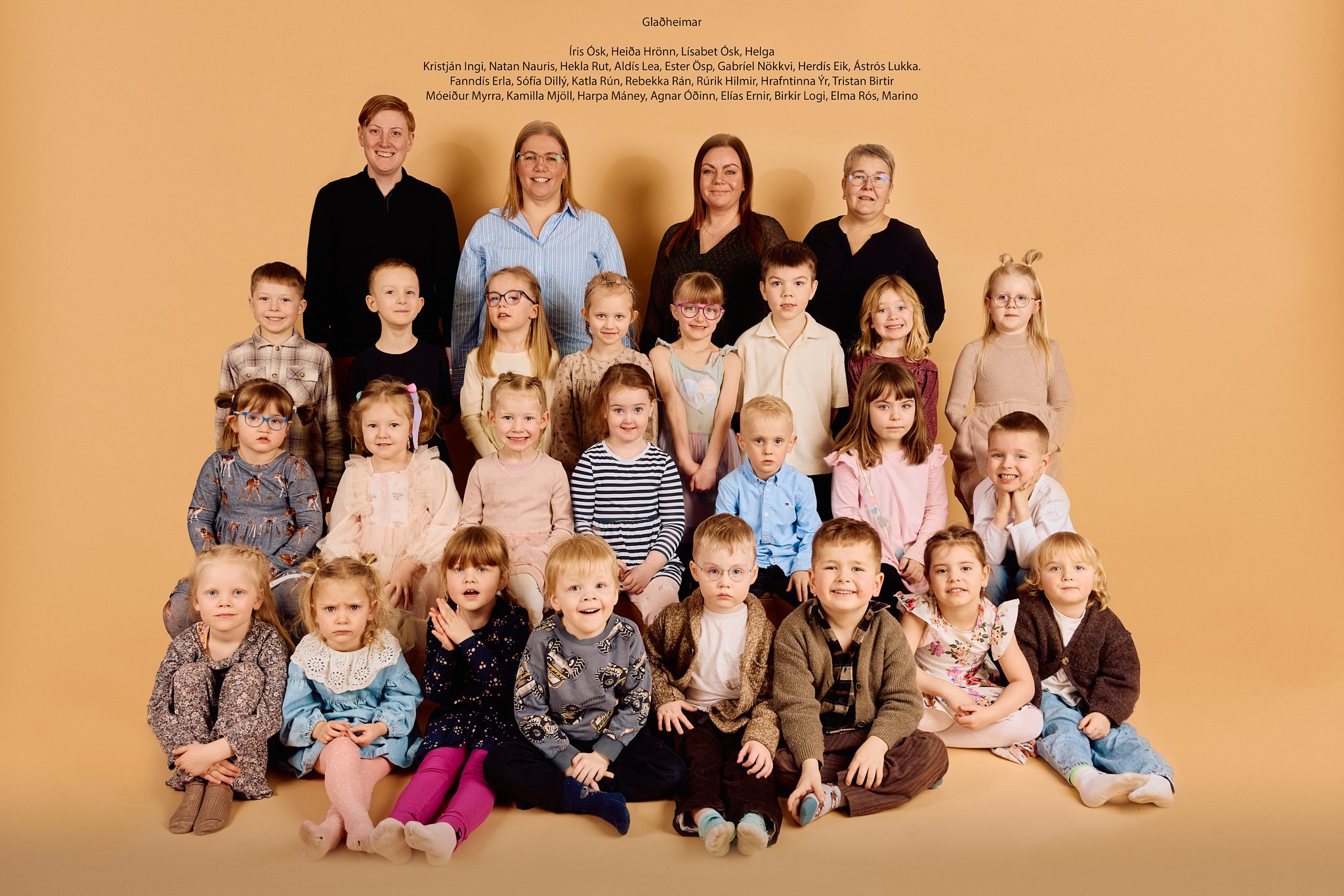 A group photo of children and adults against a beige background, with text at the top listing Icelandic names and the word 'Glaðheimar'.
