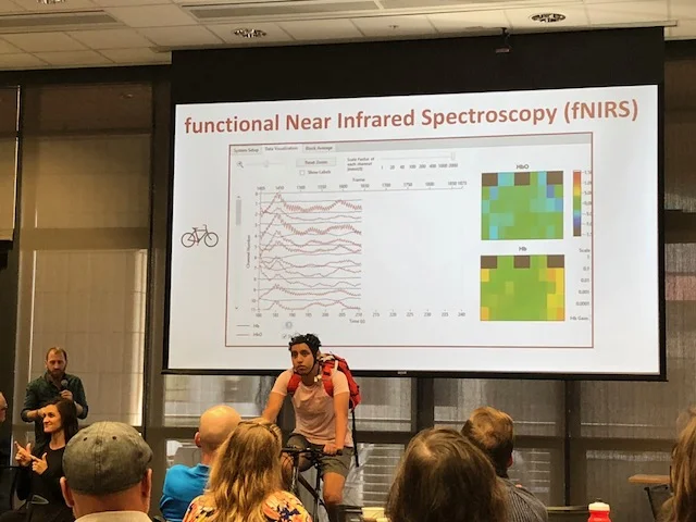 Gavin explaining the fNIRS demonstration to measure brain activity while cycling.