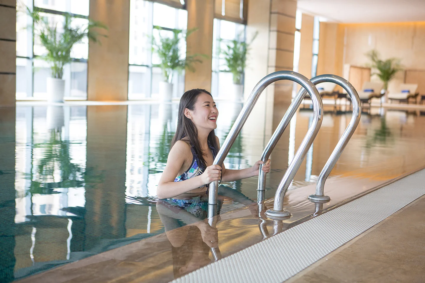 Woman Smiling Climbing Out of Hotel Pool