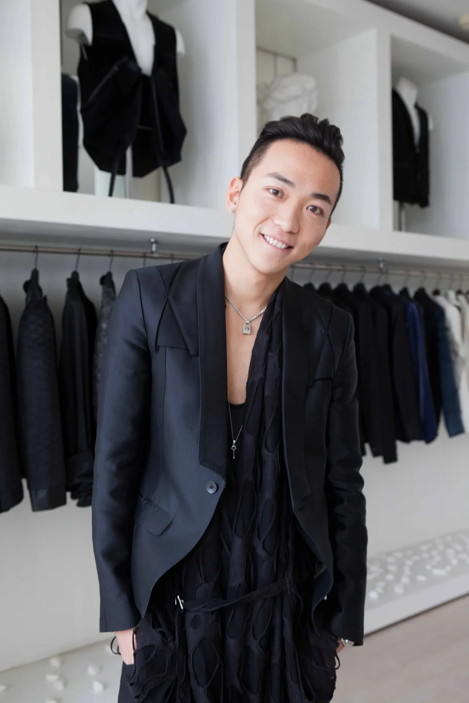 Fashionable man dressed in black posing in boutique store