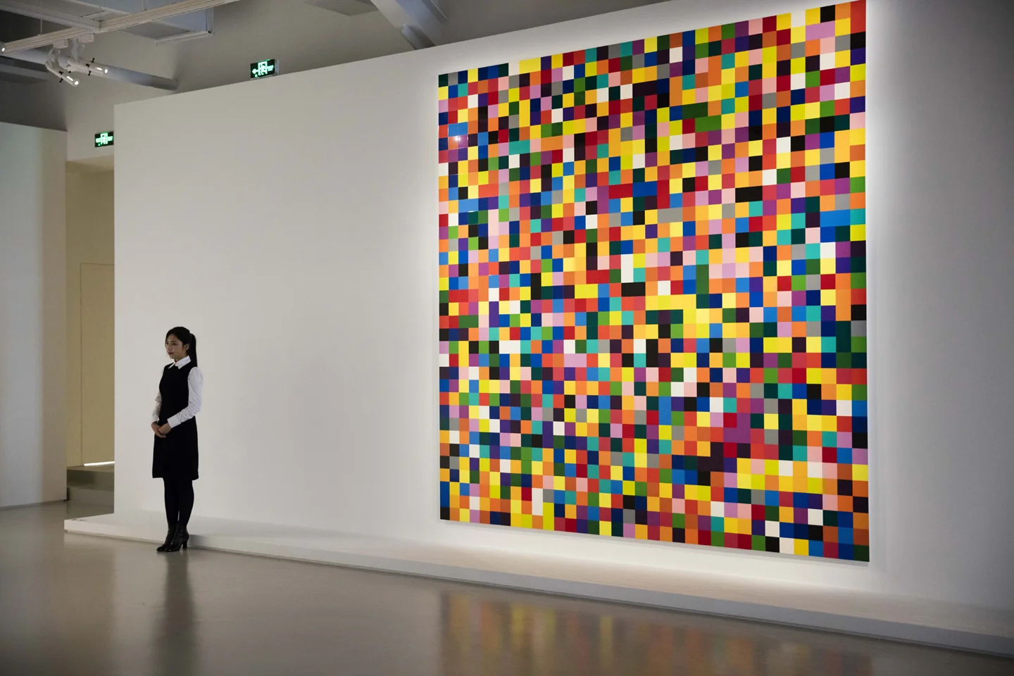 Woman standing next to large installation in art gallery