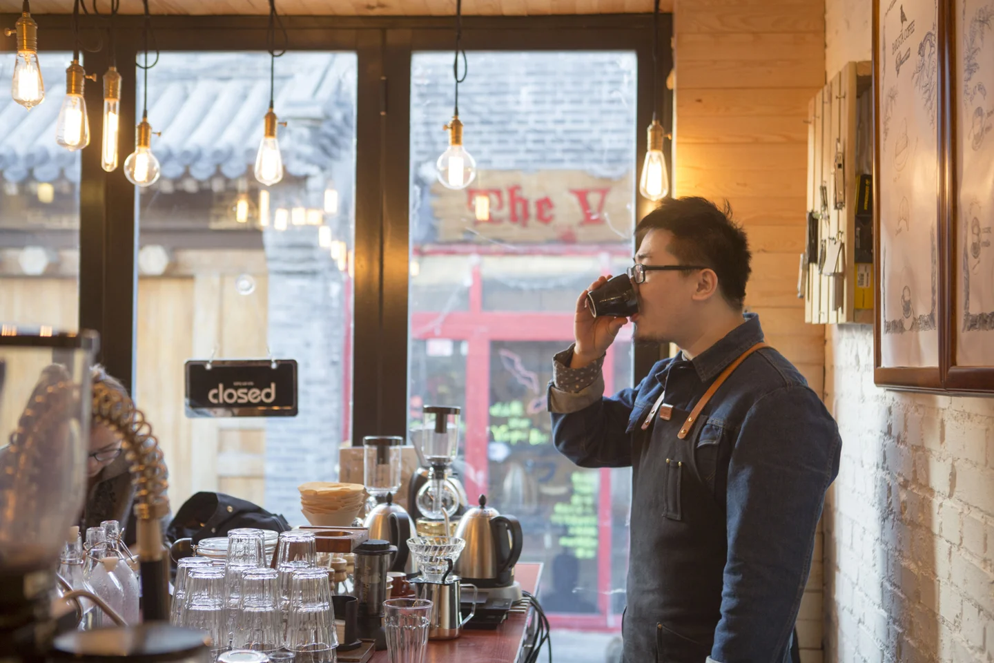 Barrista drinking cup of coffee in cafe