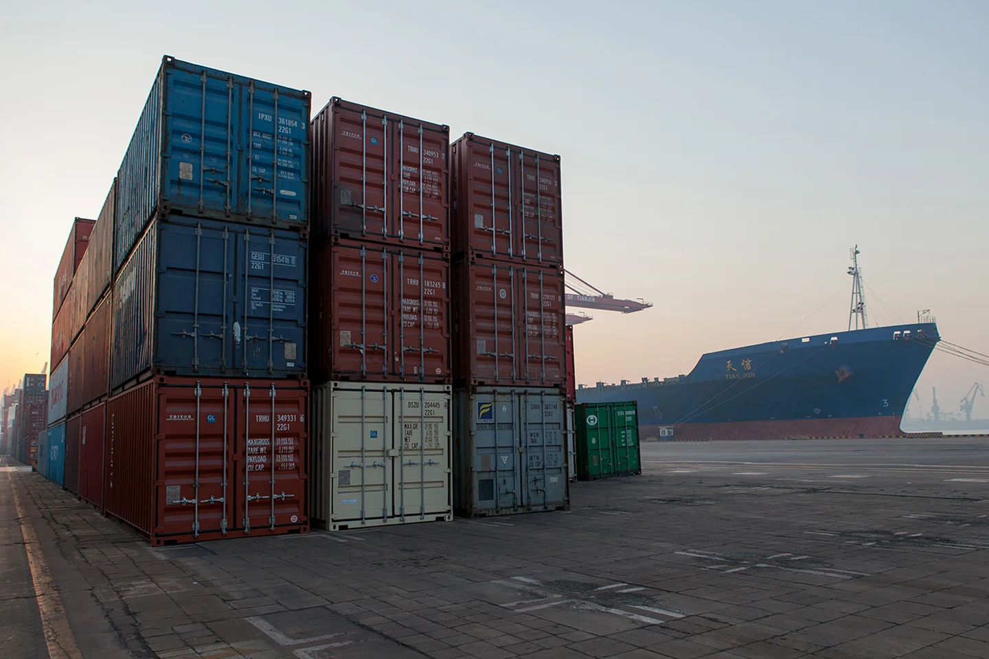 colorful shipment containers, large freighter docked in the distance