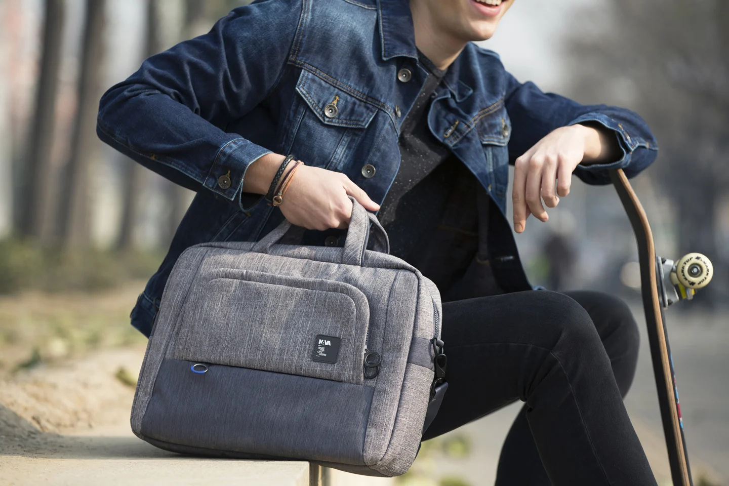 man leaning on skateboard holding bag