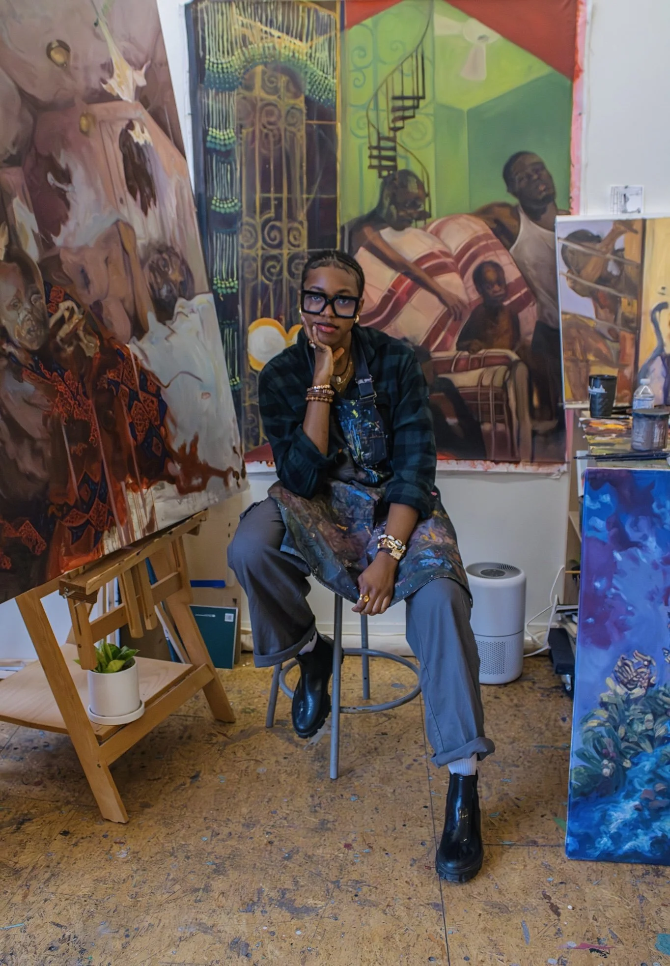Artists Kofo sits in front of her artwork at RAW.