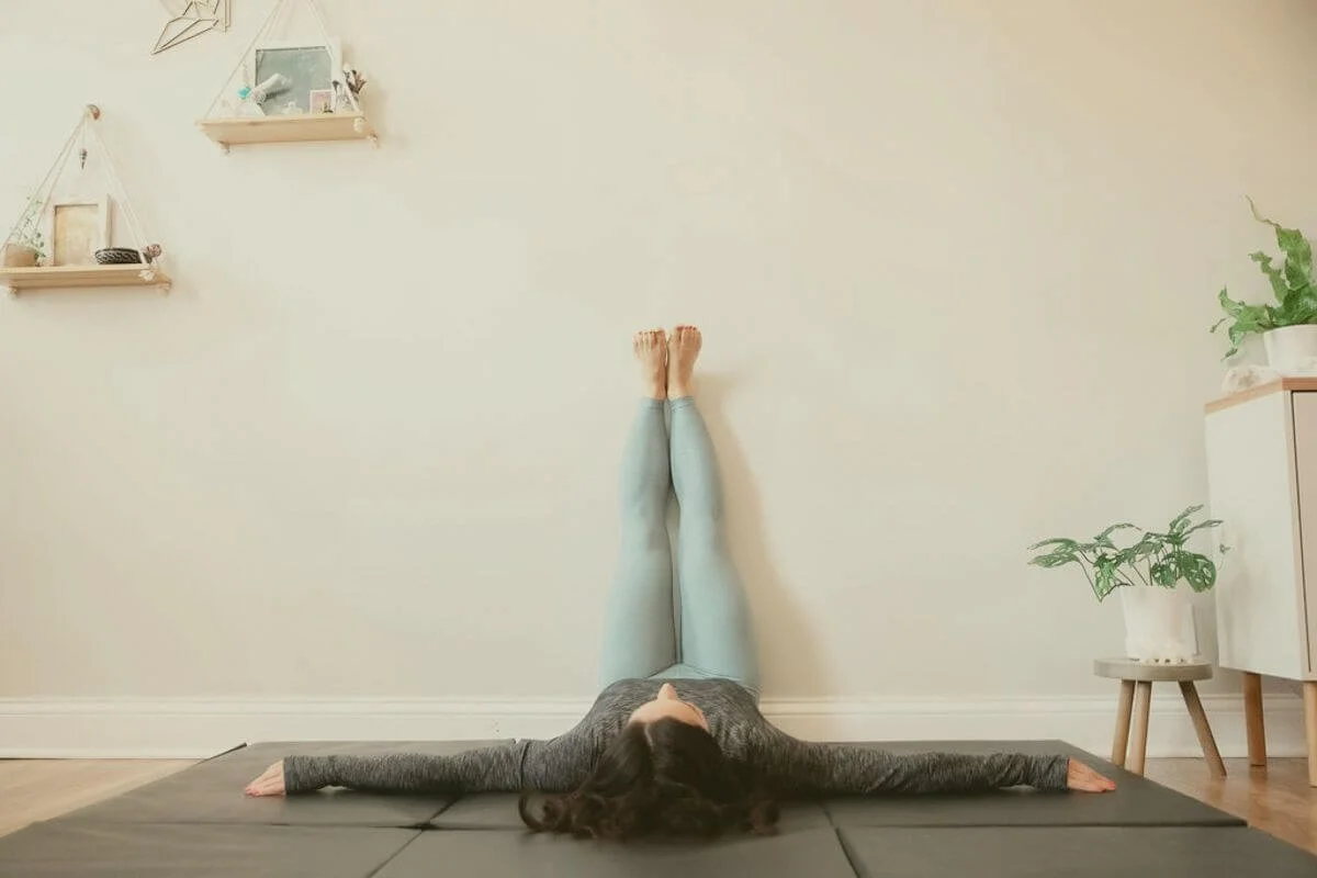 Demonstration of legs up the wall yoga pose (Viparita Karani) for relaxation and circulation