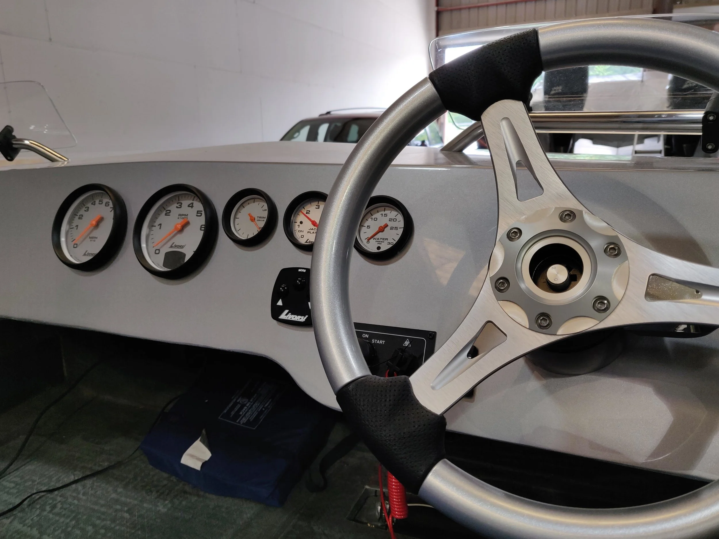 The oversize Livorsi Marine platinum dials, with mega rims look very clean. The dash is all business. The Evinrude Icon screen fits nicely on the starboard side of the helm. The wheel is from Livorsi Marine as well. The seat pictured is just for tes…