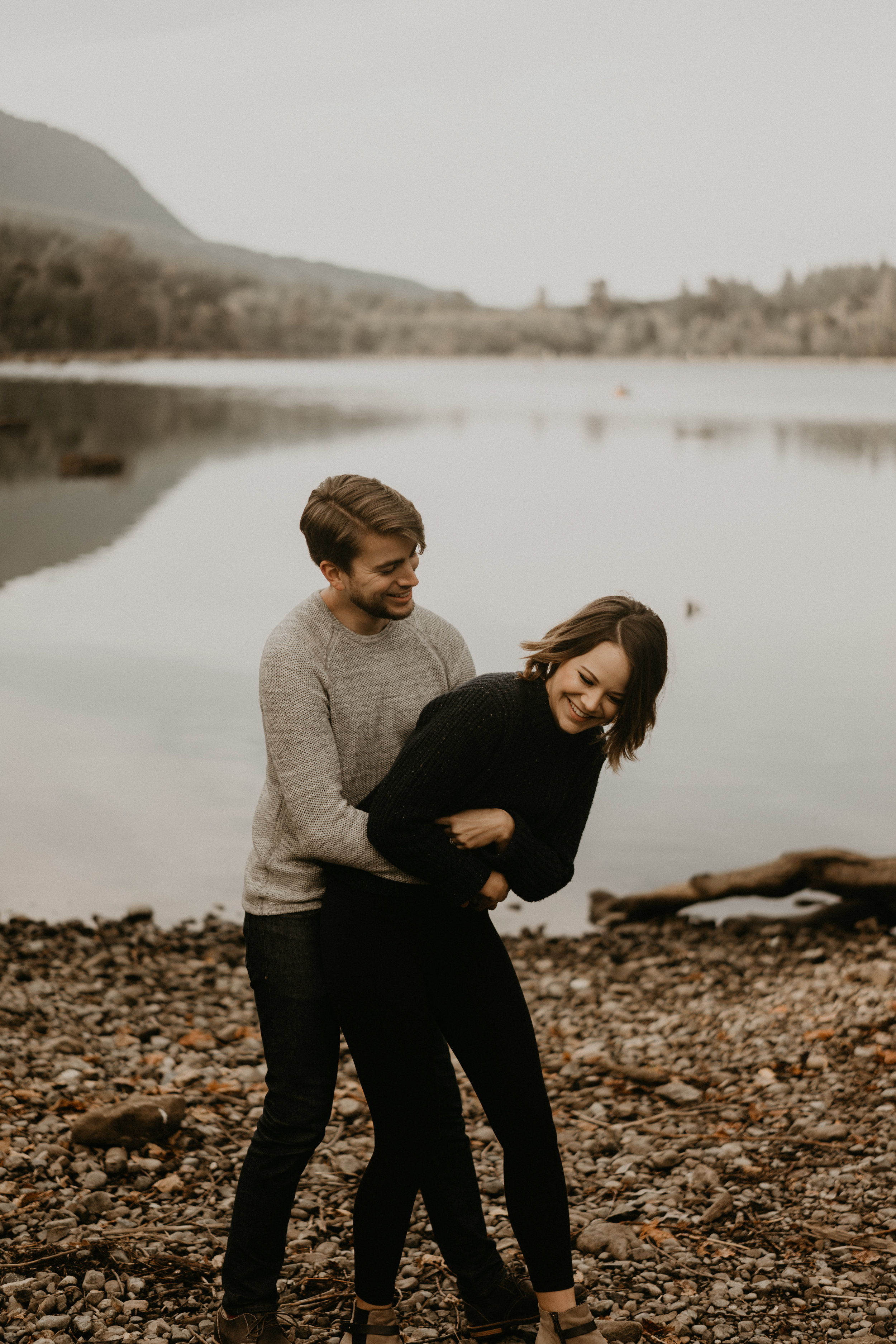 couple having fun for their engagement photos by rattlesnake lake