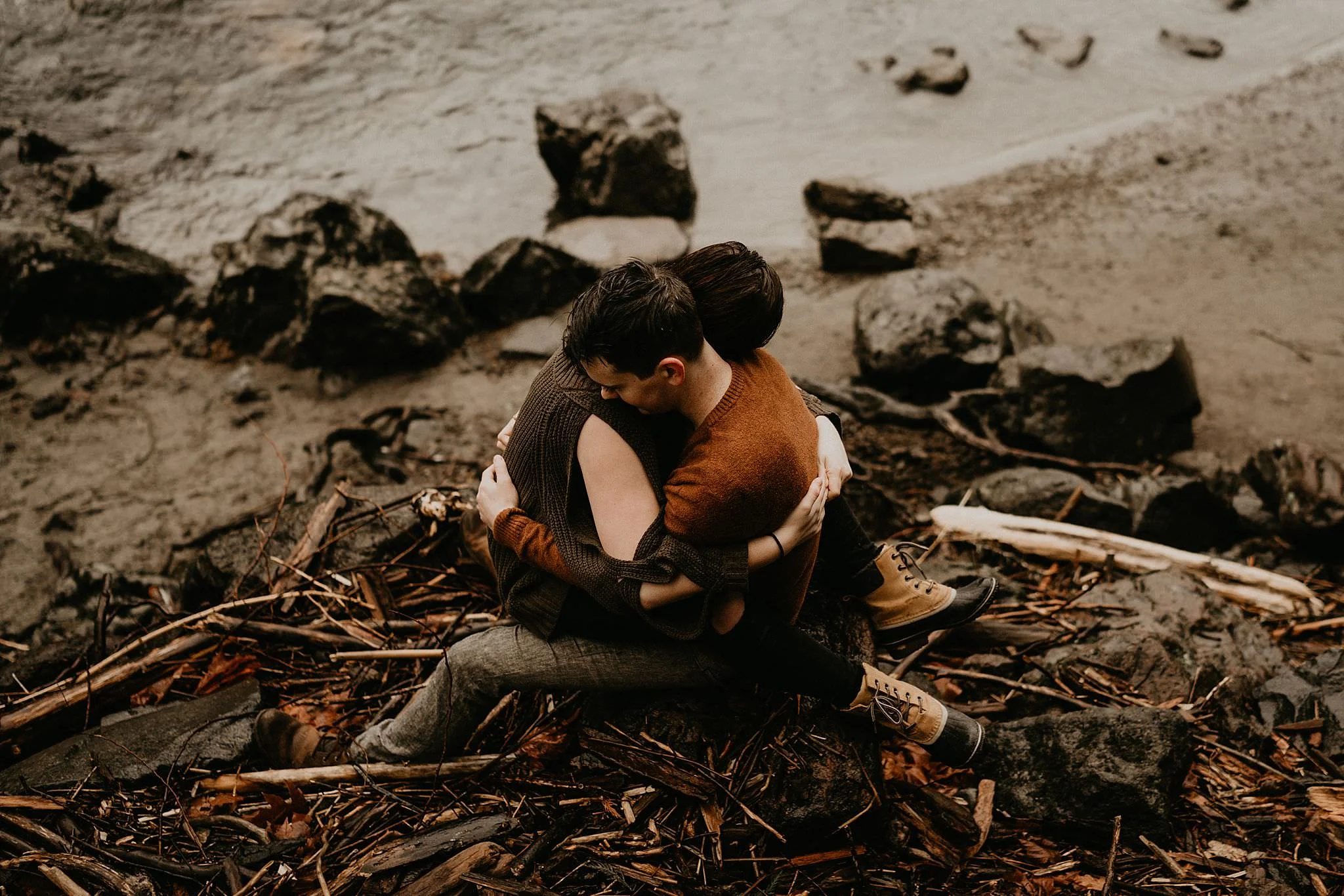 Couple holding each other in front of Snoqualmie Falls in the rain