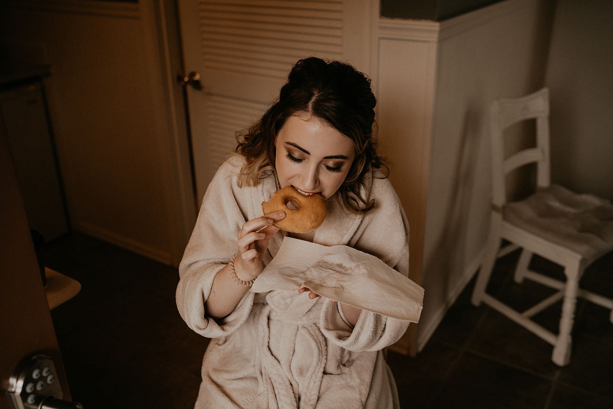 Bride eating donut while getting ready for her intimate wedding at Ebey's landing on Whidbey island
