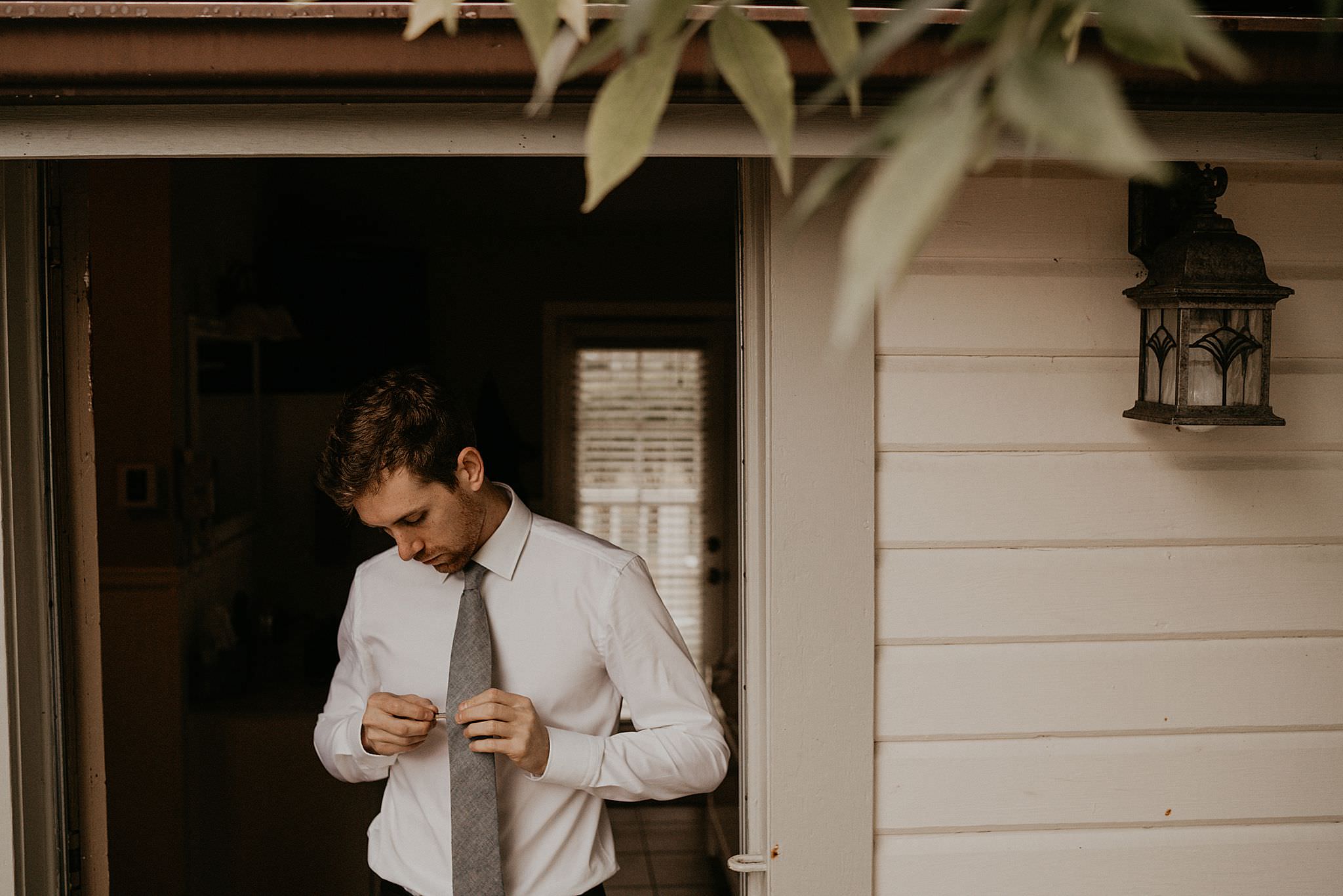 Groom getting read in his gray suit for his intimate wedding at Ebey's landing on Whidbey island