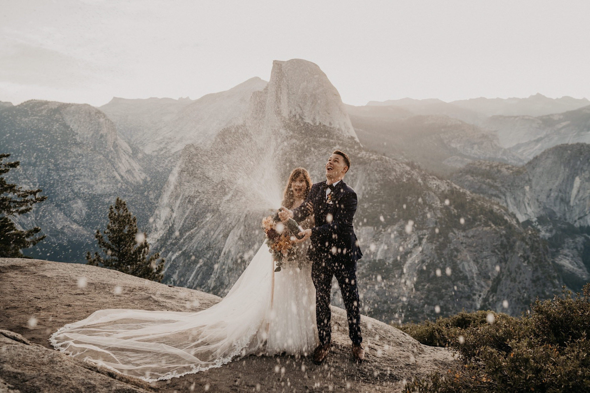 Bride and groom popped champagne to celebrate their elopement at Yosemite National Park during sunrise on Glacier Point