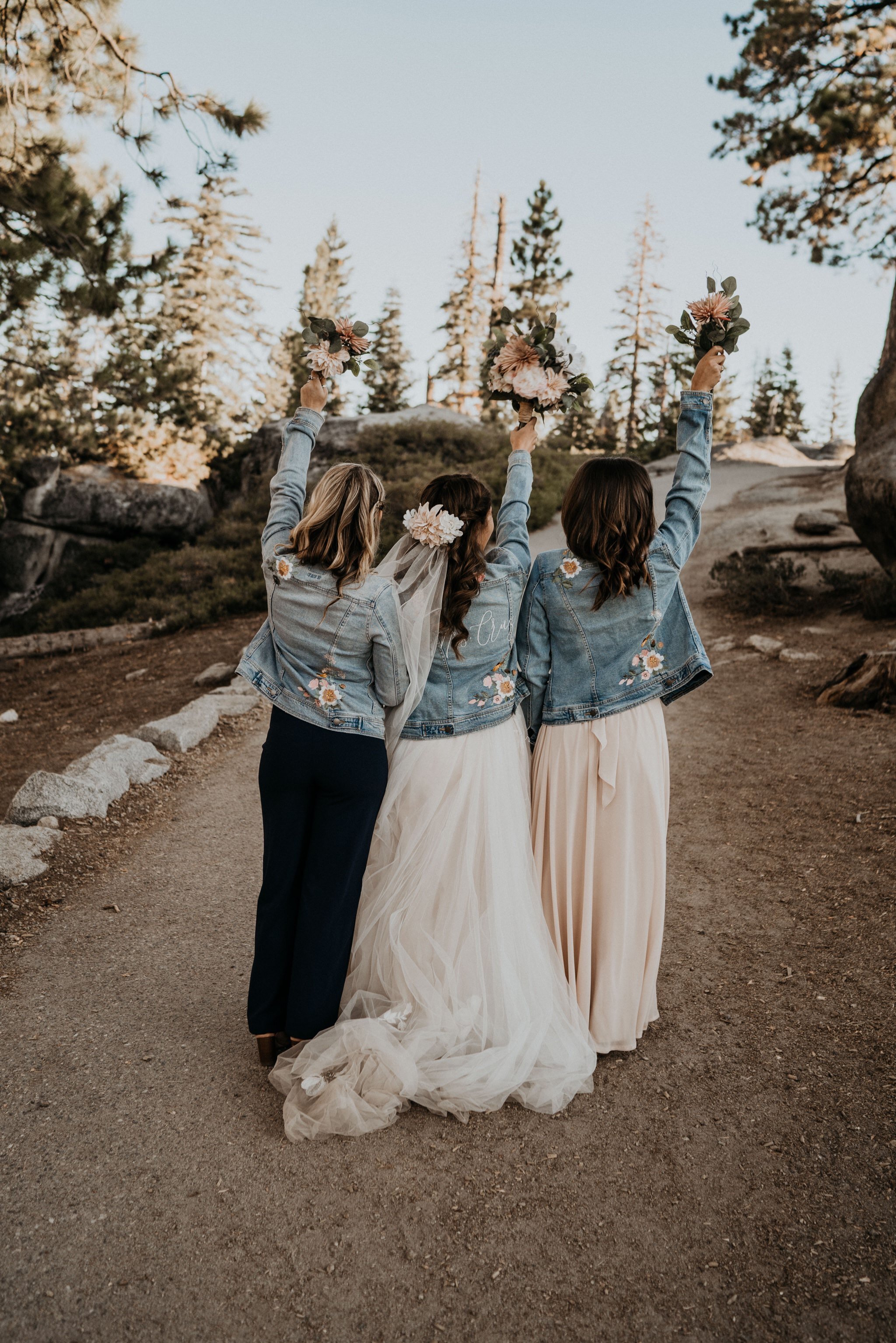 Matching denim jackets bride and bridesmaid Dearly Threaded | Yosemite National Park elopement and wedding photos at Glacier Point during sunrise with view of Half Dome