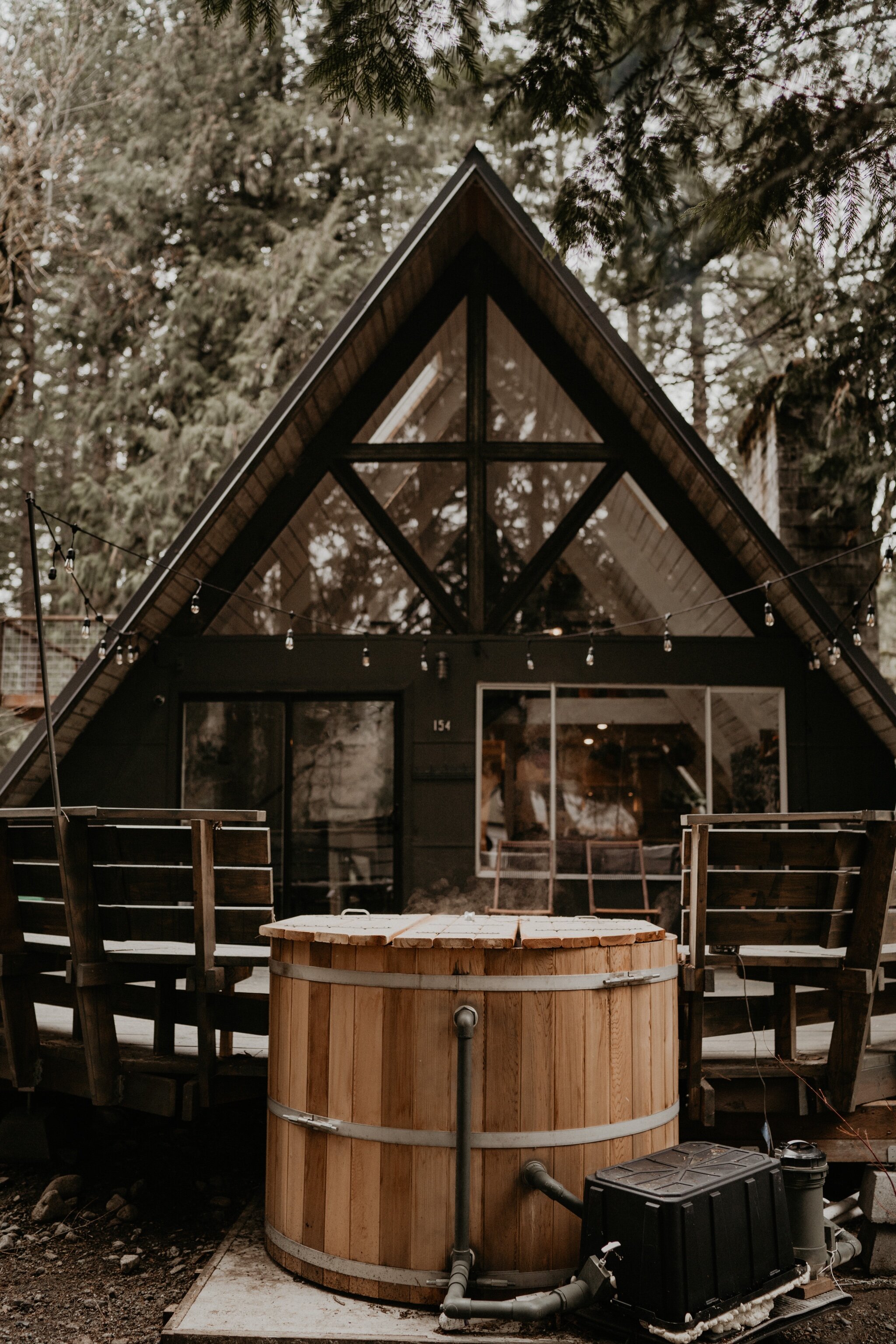 Couple stay in a hot tub for their Intimate steamy in-home engagement session at an A-Frame Cabin in Mount Rainier National Park