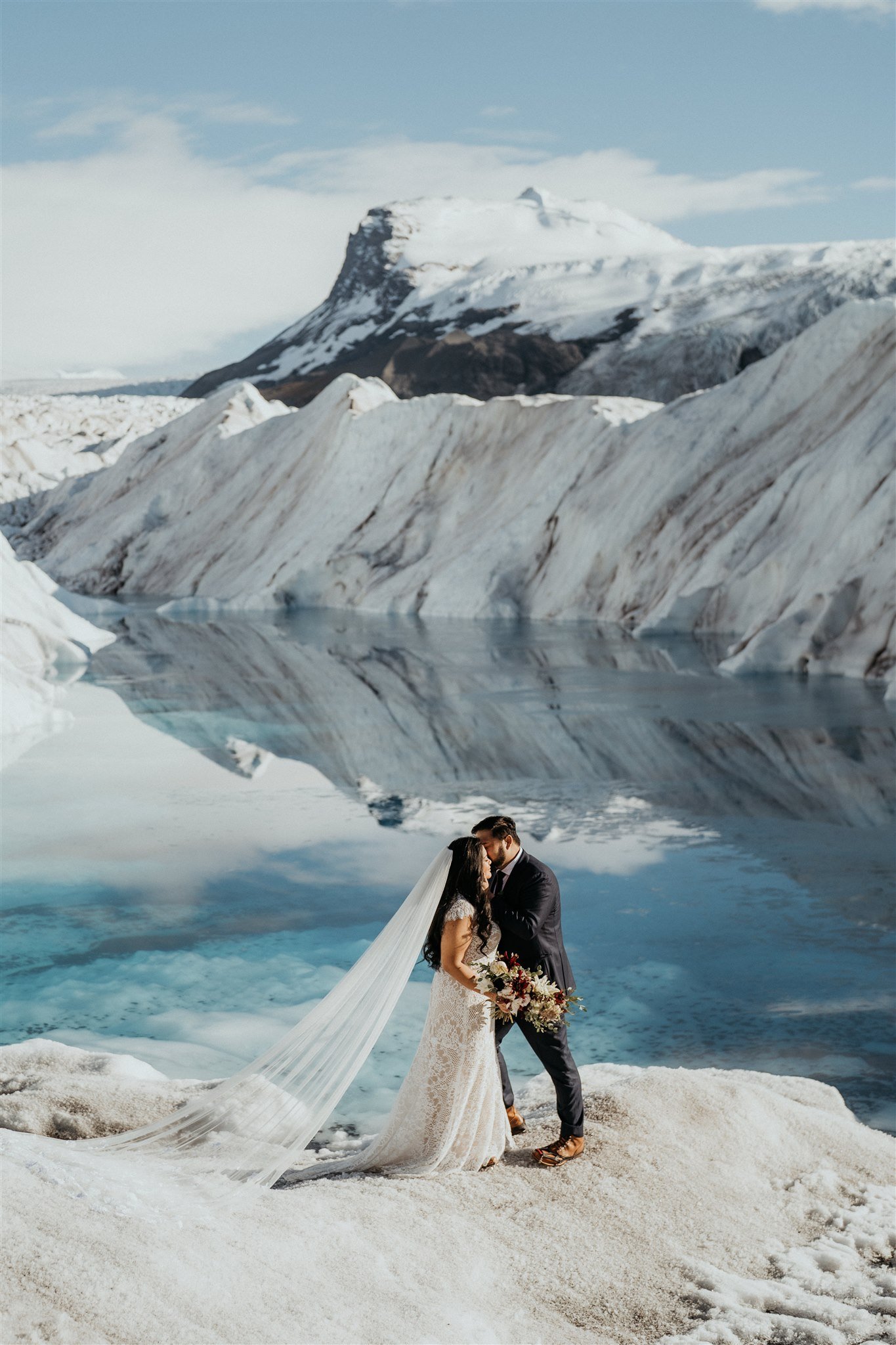 Bride and groom first kiss at Alaska elopement on a glacier