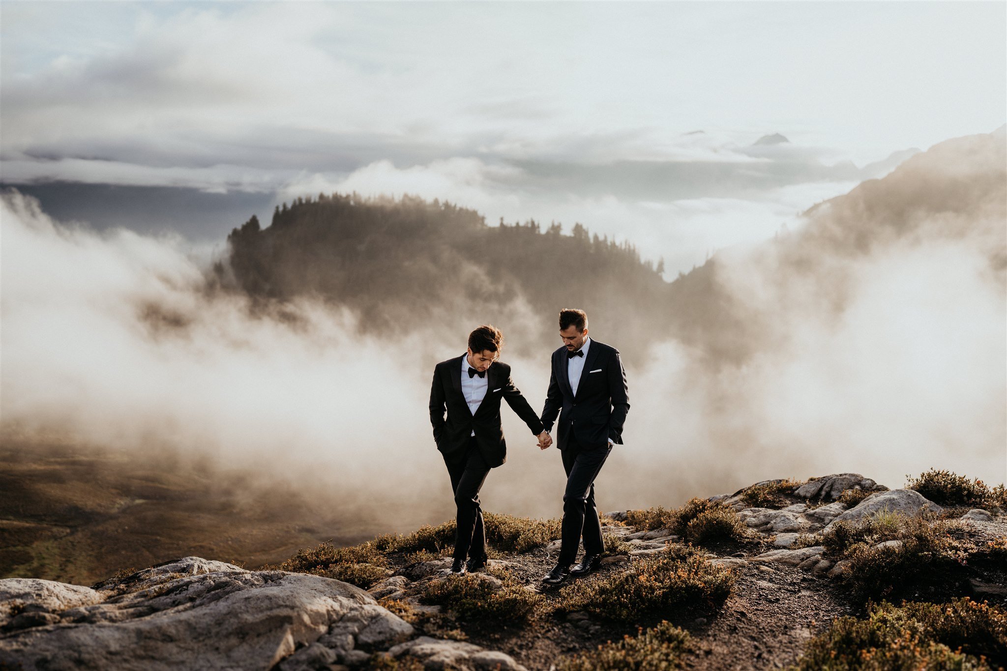 Two grooms holding hands walking in the mountains at North Cascades for their PNW elopement