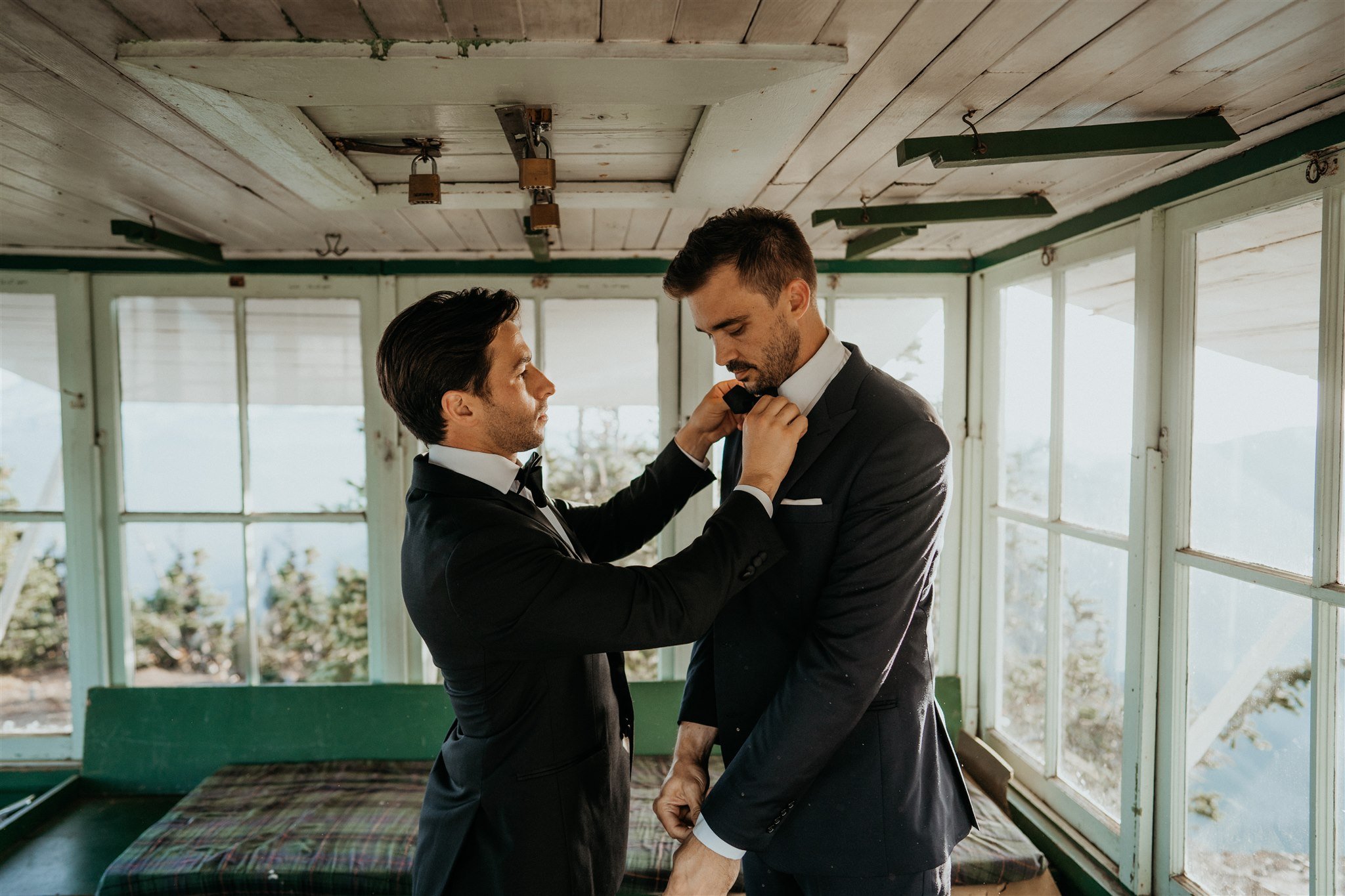 Two grooms getting ready in a fire lookout in the North Cascades mountains