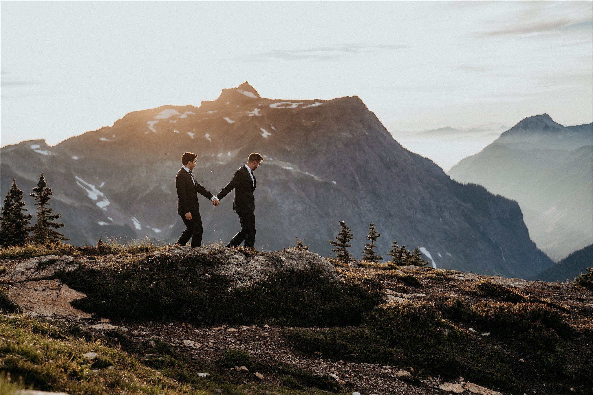 Two grooms walking in the North Cascades for their mountain elopement.