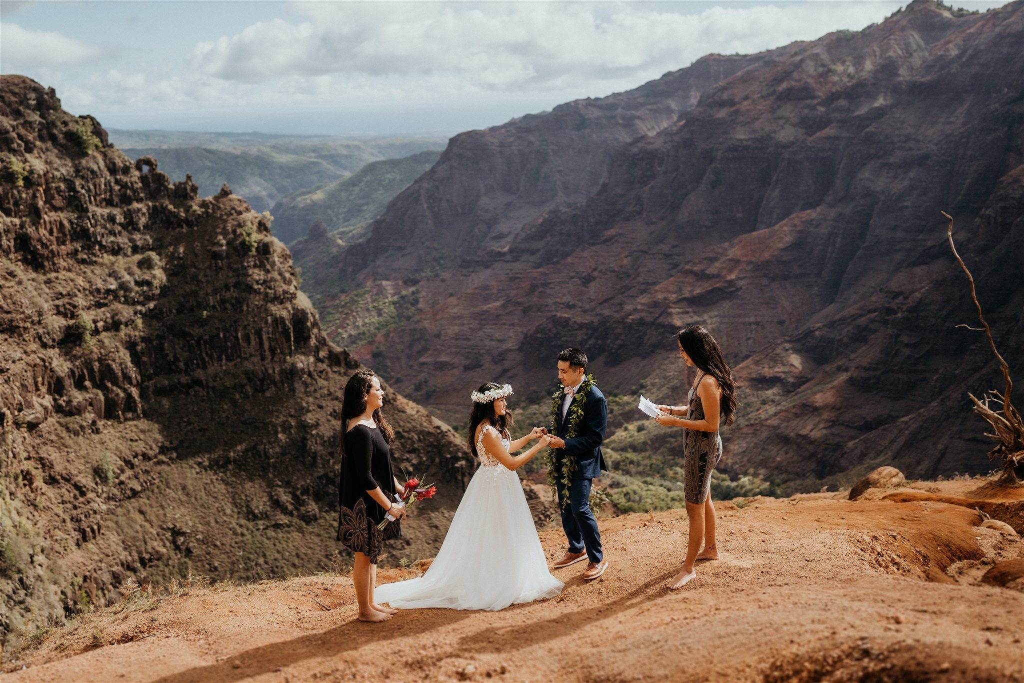 Bride and groom holding hands during elopement ceremony in Kauai