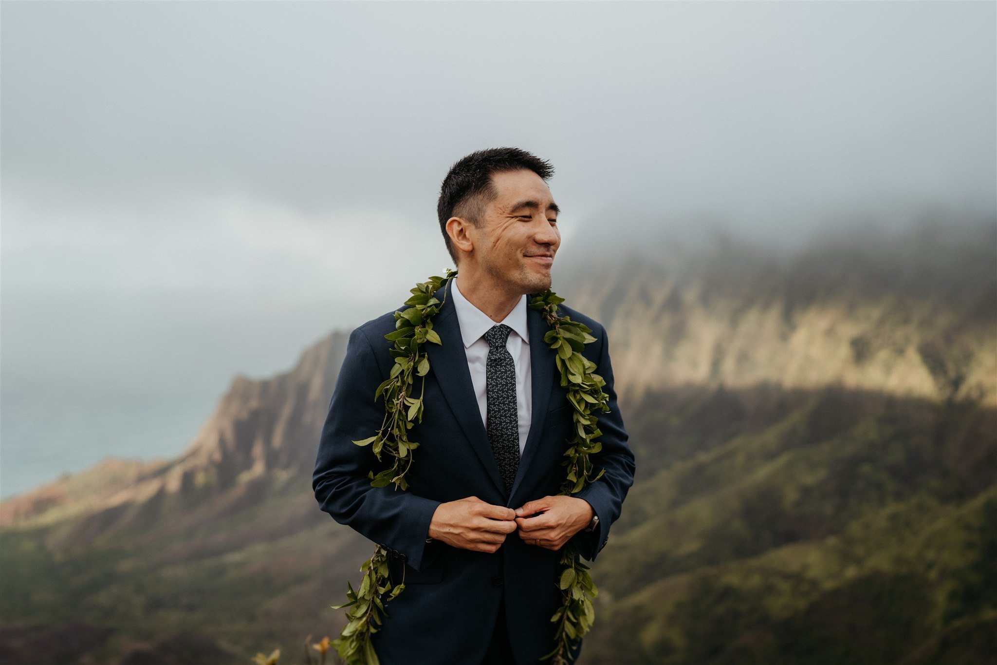 Groom standing at an overlook in Hawaii for adventure elopement