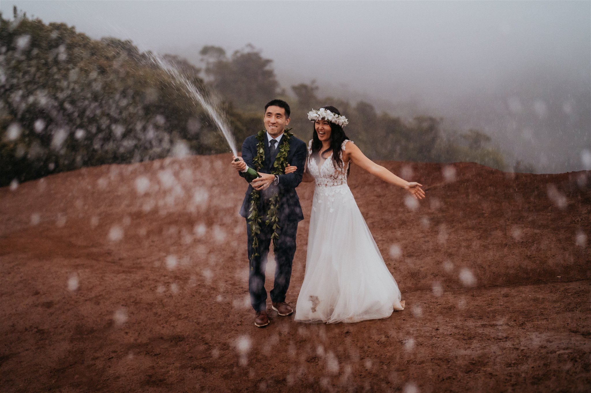 Bride and groom spraying champagne to celebrate their elopement