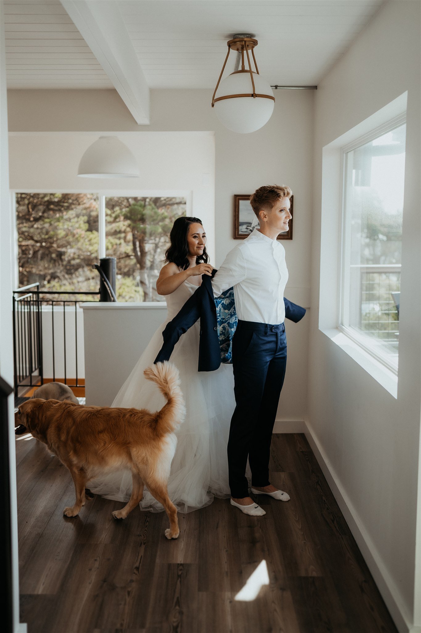 Two brides helping each other get ready for their Oregon Coast elopement