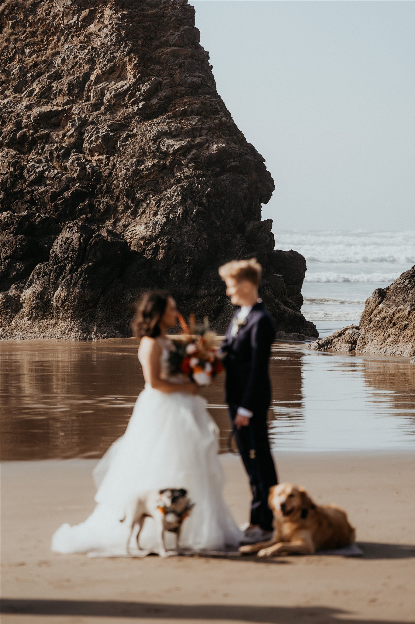 Two brides standing on the beach for their Oregon Coast elopement