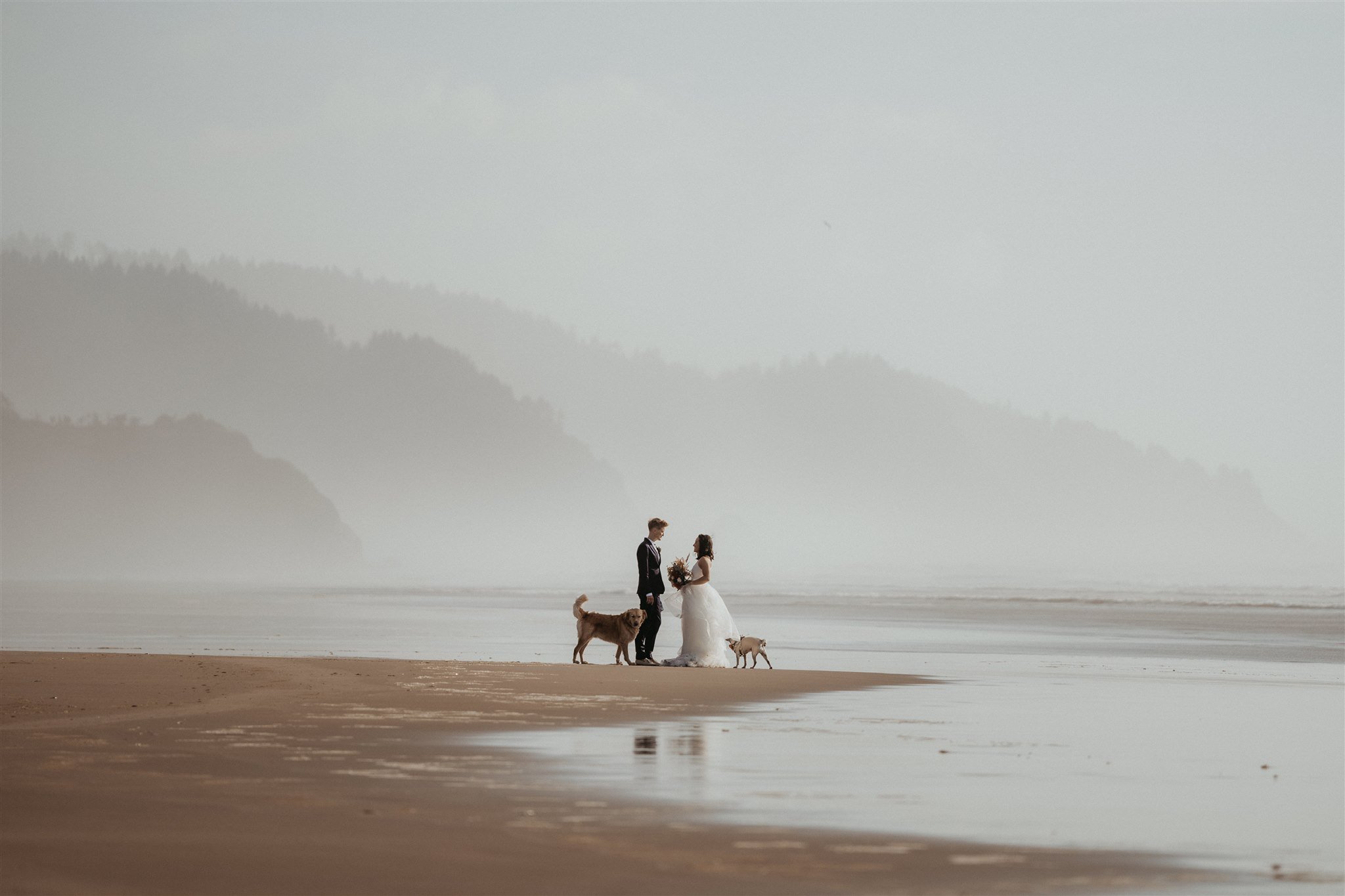 Two brides walking down the beach for their Oregon Coast elopement