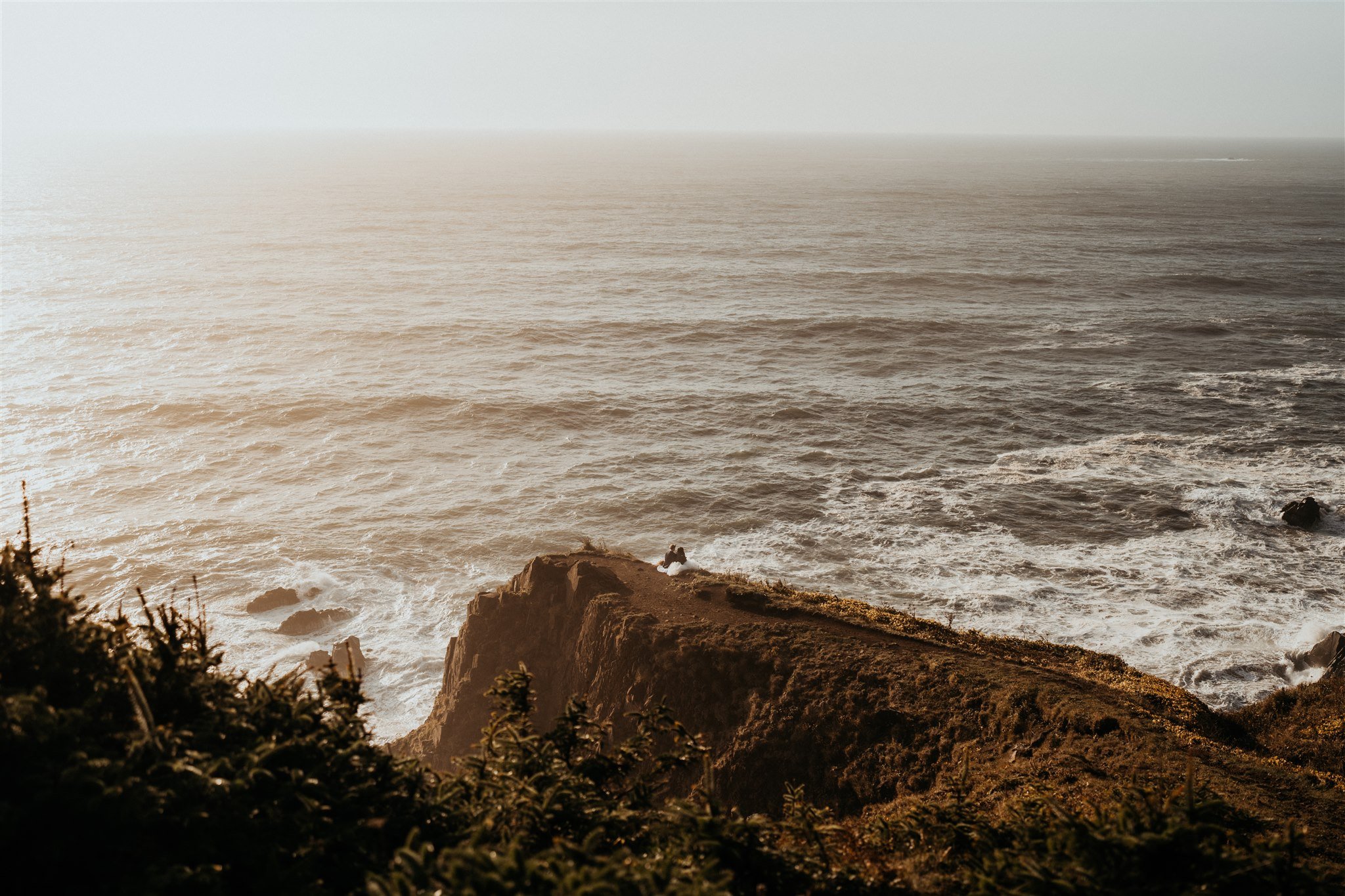 Two brides walking on a trail at sunset on the Oregon cliffs