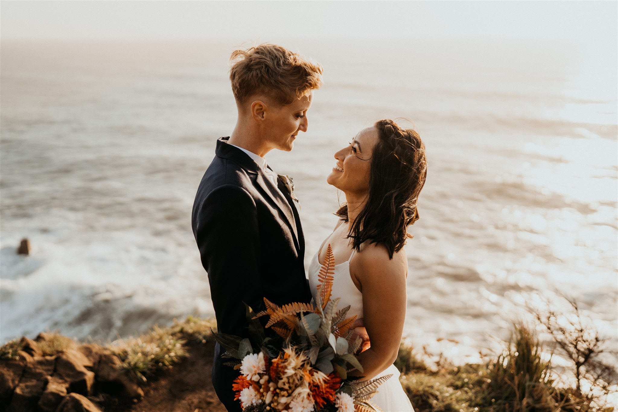 Two brides embrace during Oregon Coast elopement