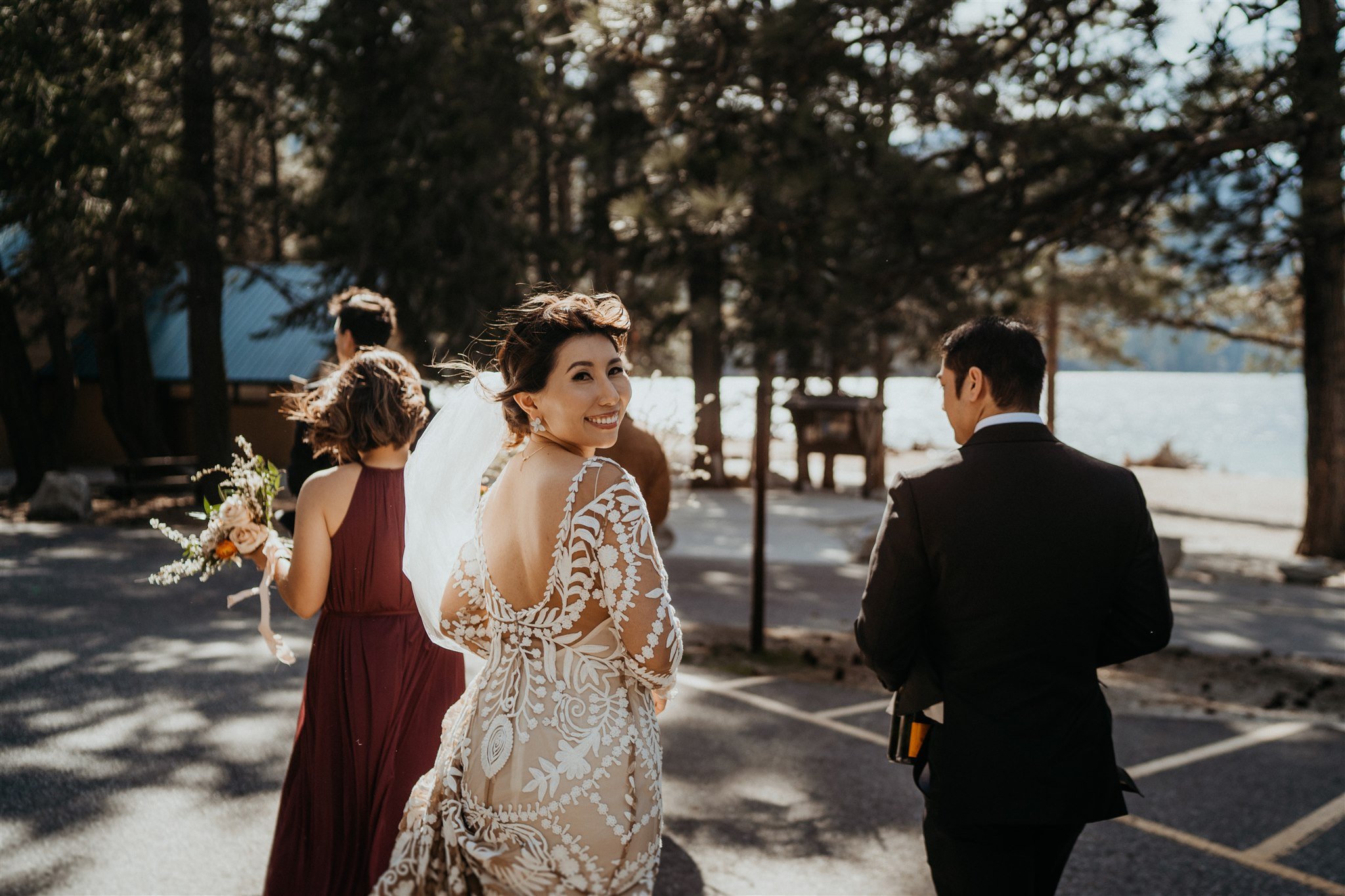 Bride smiling back at the camera while walking to the elopement ceremony location at Lake Wenatchee