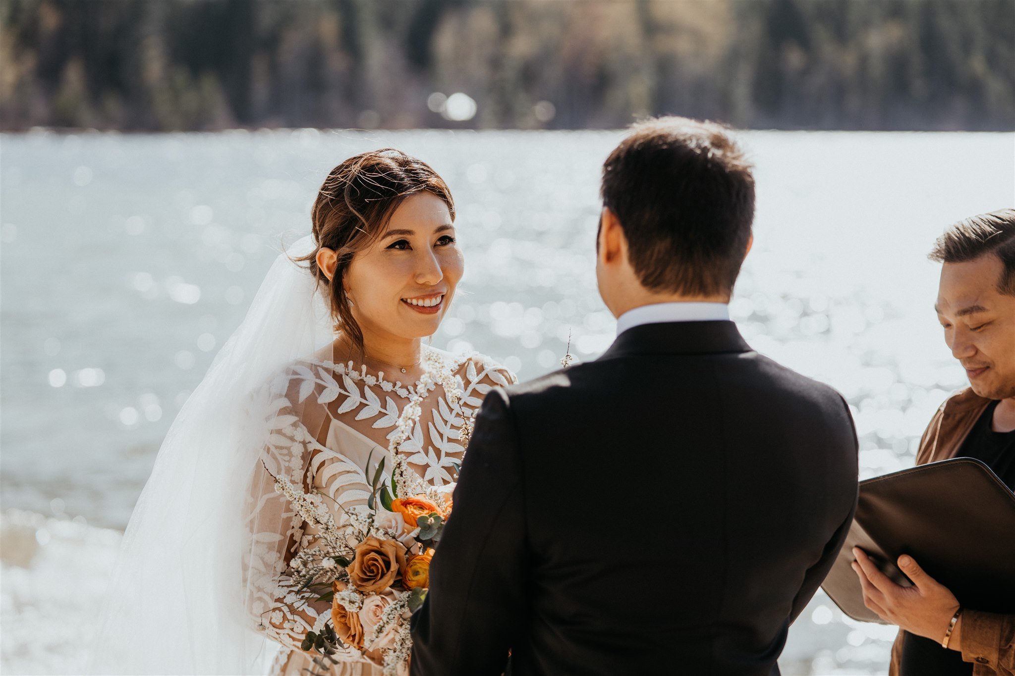 Bride looking at groom and smiling during Lake Wenatchee elopement ceremony