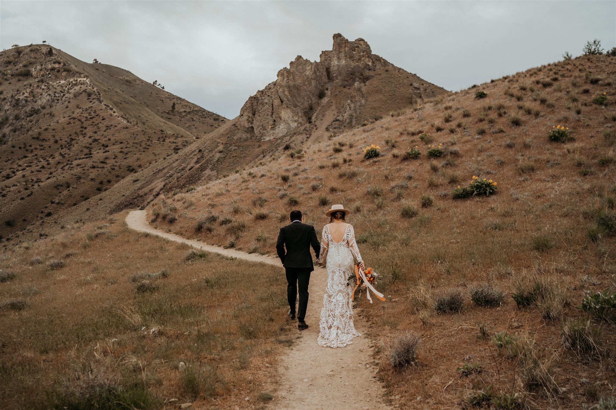 Bride and groom walking down a trail for their hiking elopement in the North Cascades