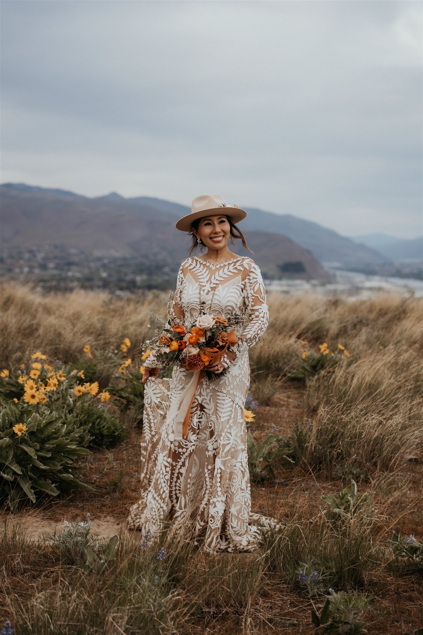 Bride holding orange and white bouquet