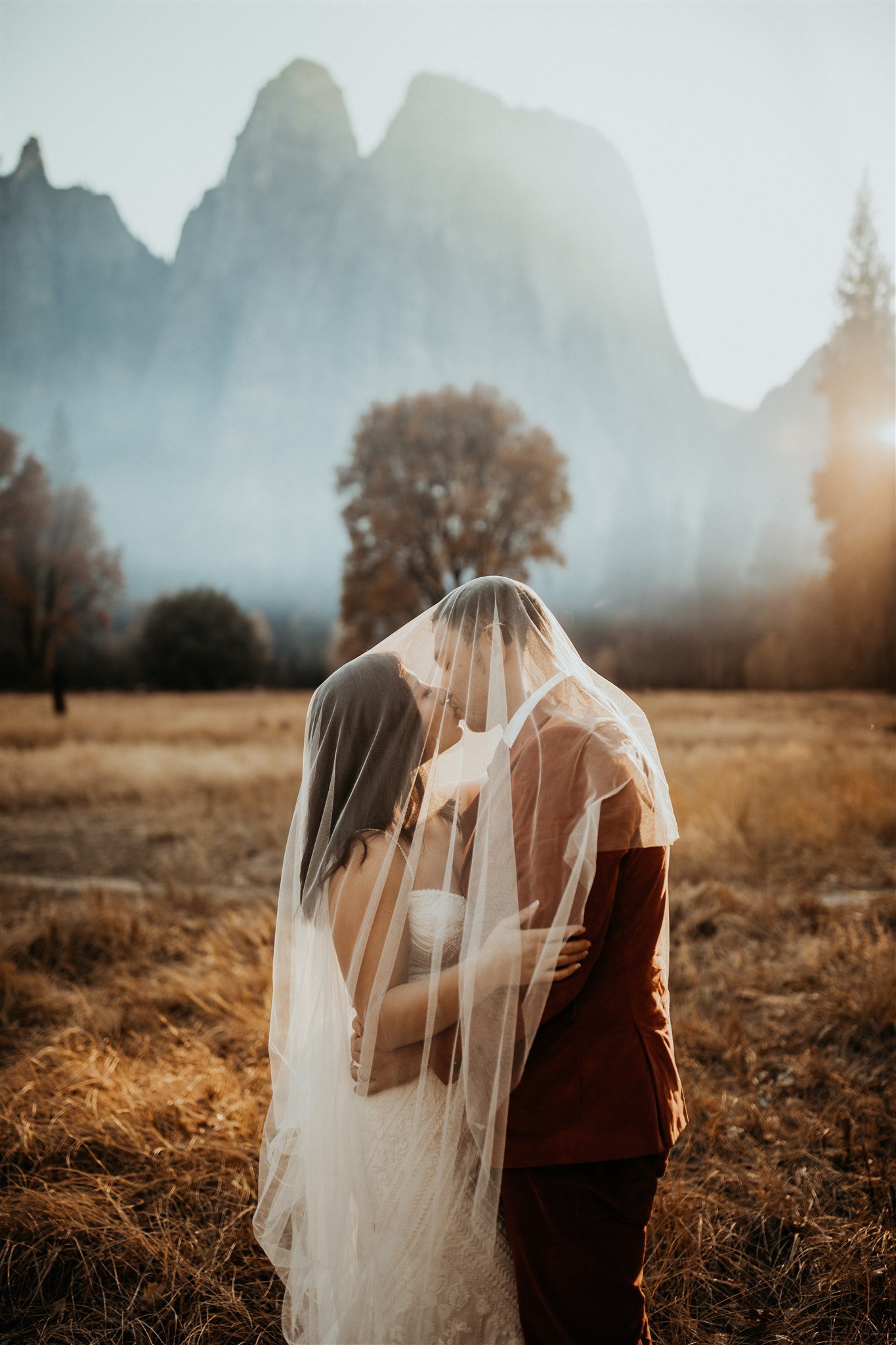 Bride and groom kissing under veil at Yosemite elopement
